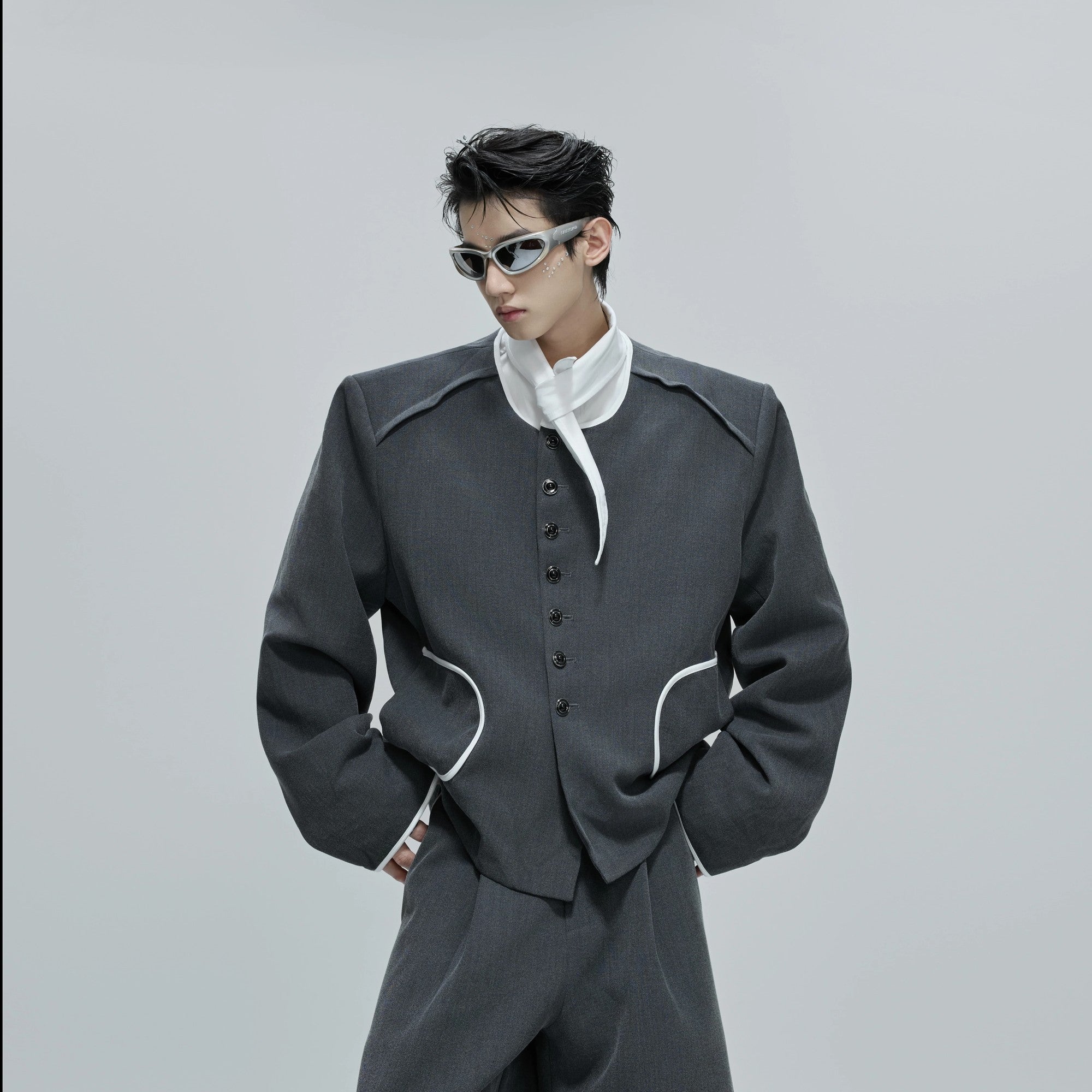 Model wearing gray tweed jacket and pants set in street setting