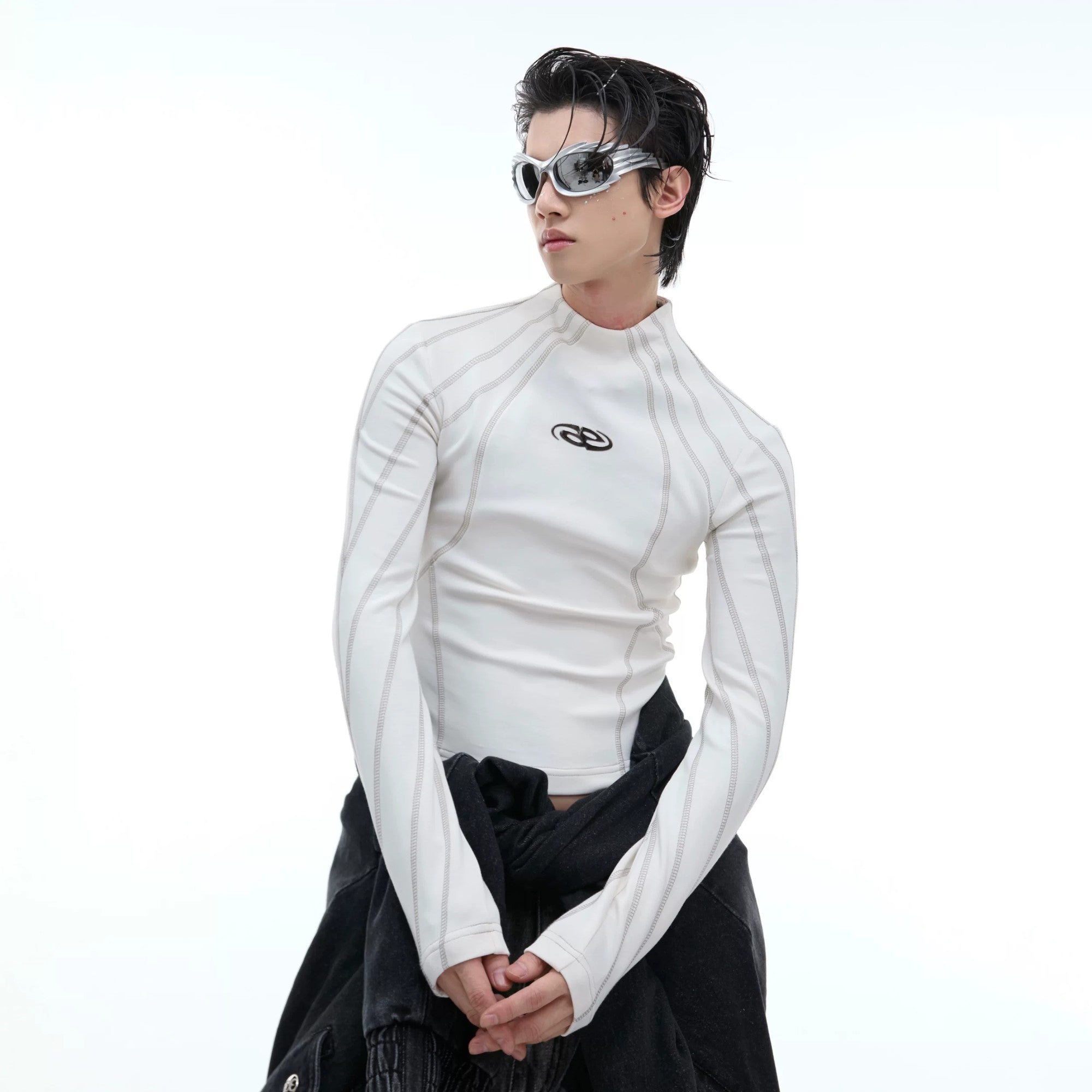 Black long sleeve crop top featuring deconstructed lines and metal accents