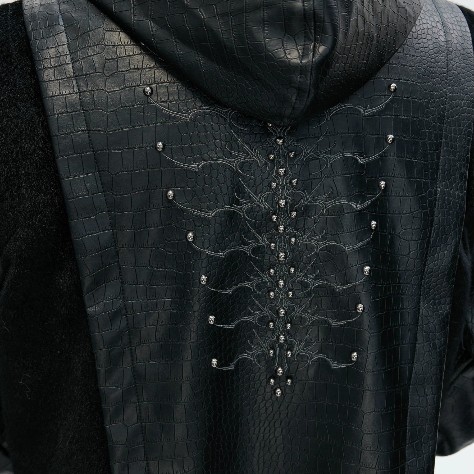 Model wearing oversized gothic padded jacket in urban setting