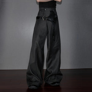 Close-up of metallic rivets and deconstructed patchwork on streetwear pants.