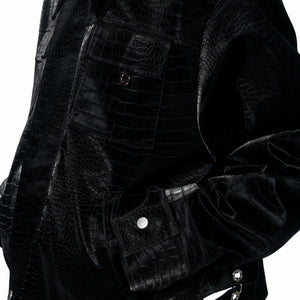 Close-up of metal snap buttons and zipper on croc-embossed leather