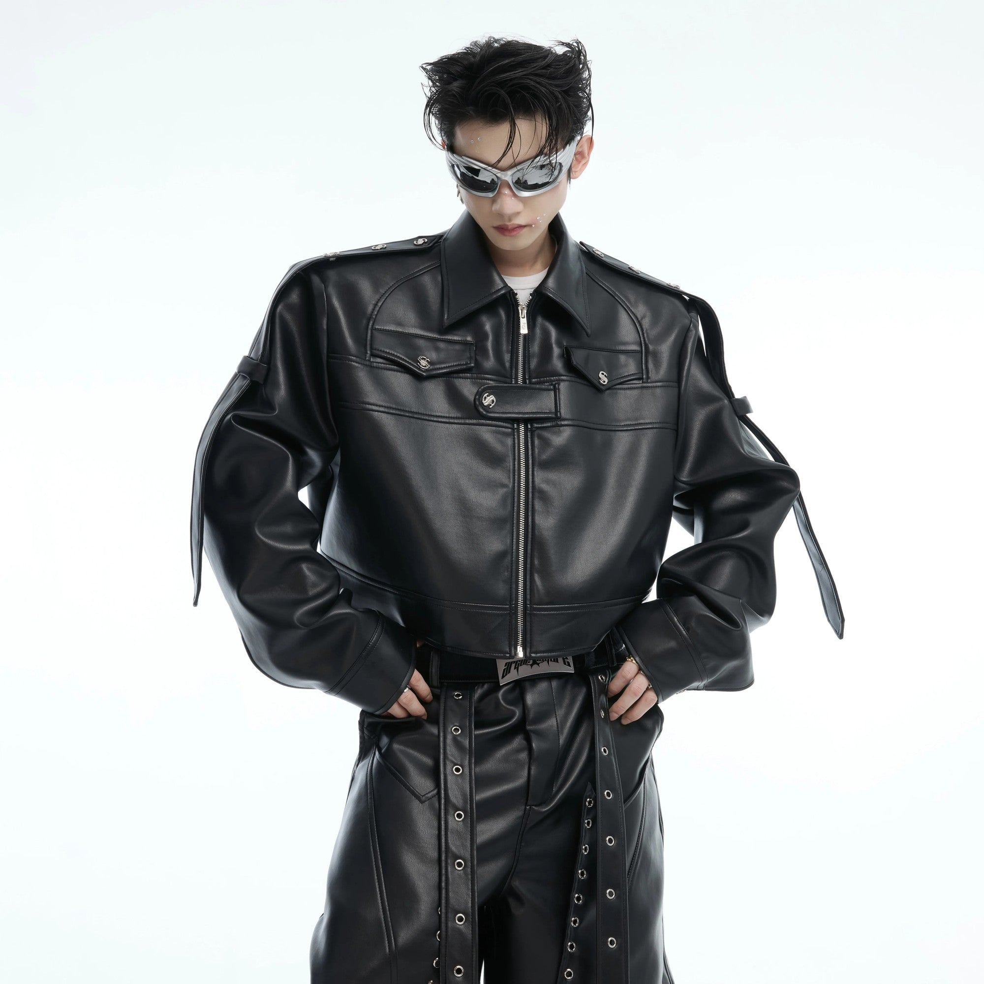 Front view of a black cropped deconstructed moto jacket with metal accents