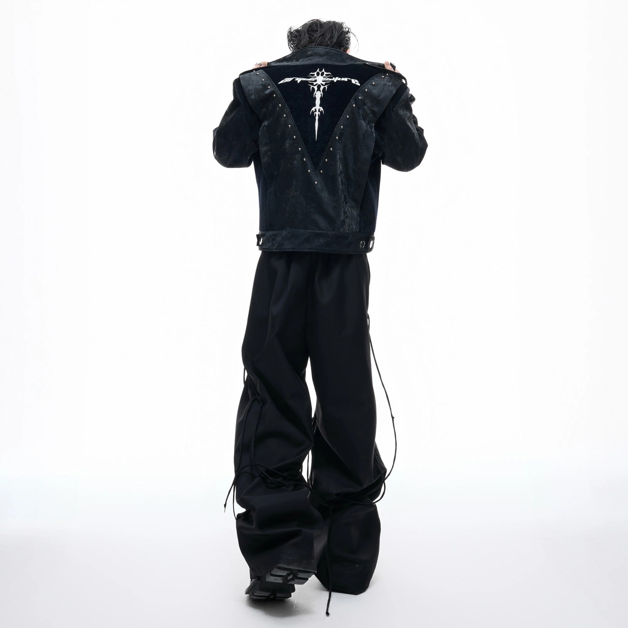 Male model wearing cropped studded biker jacket in urban setting