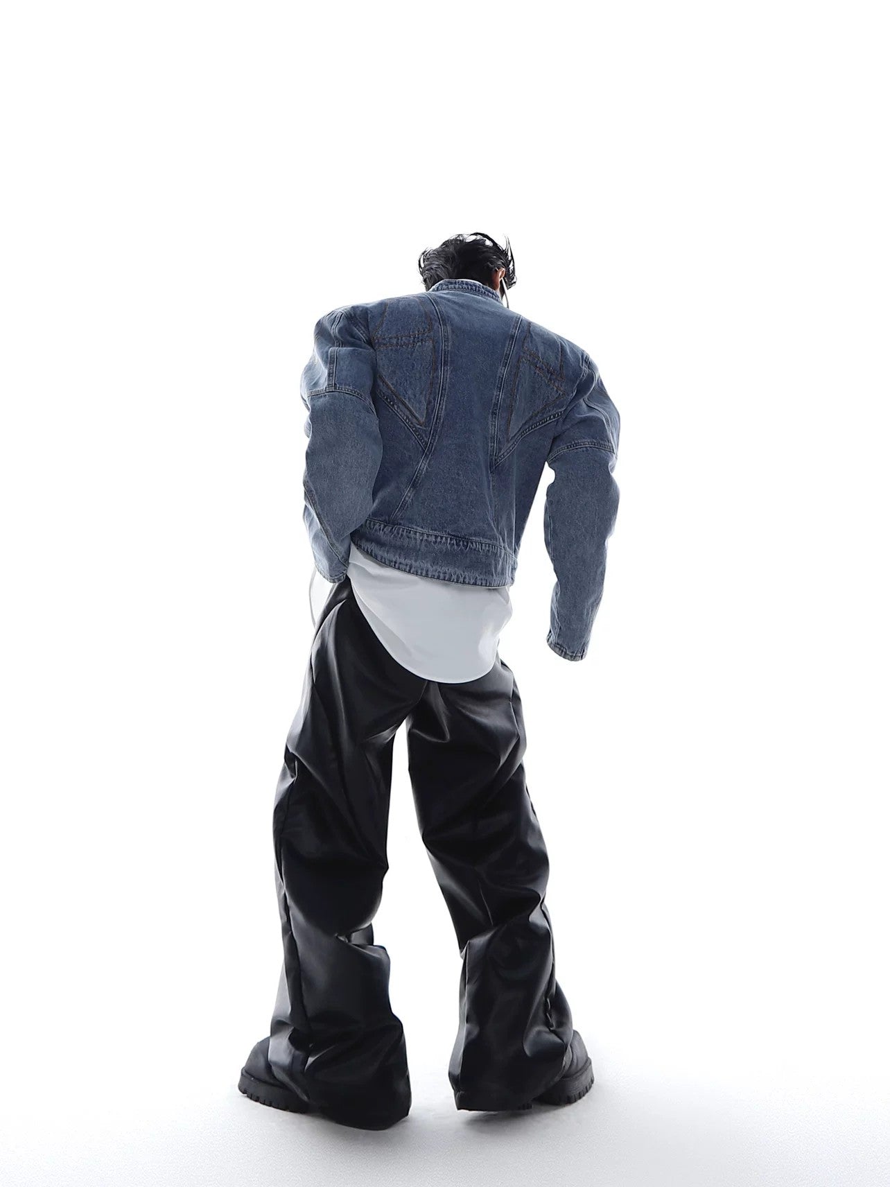 Side profile showing padded shoulder silhouette of denim moto jacket