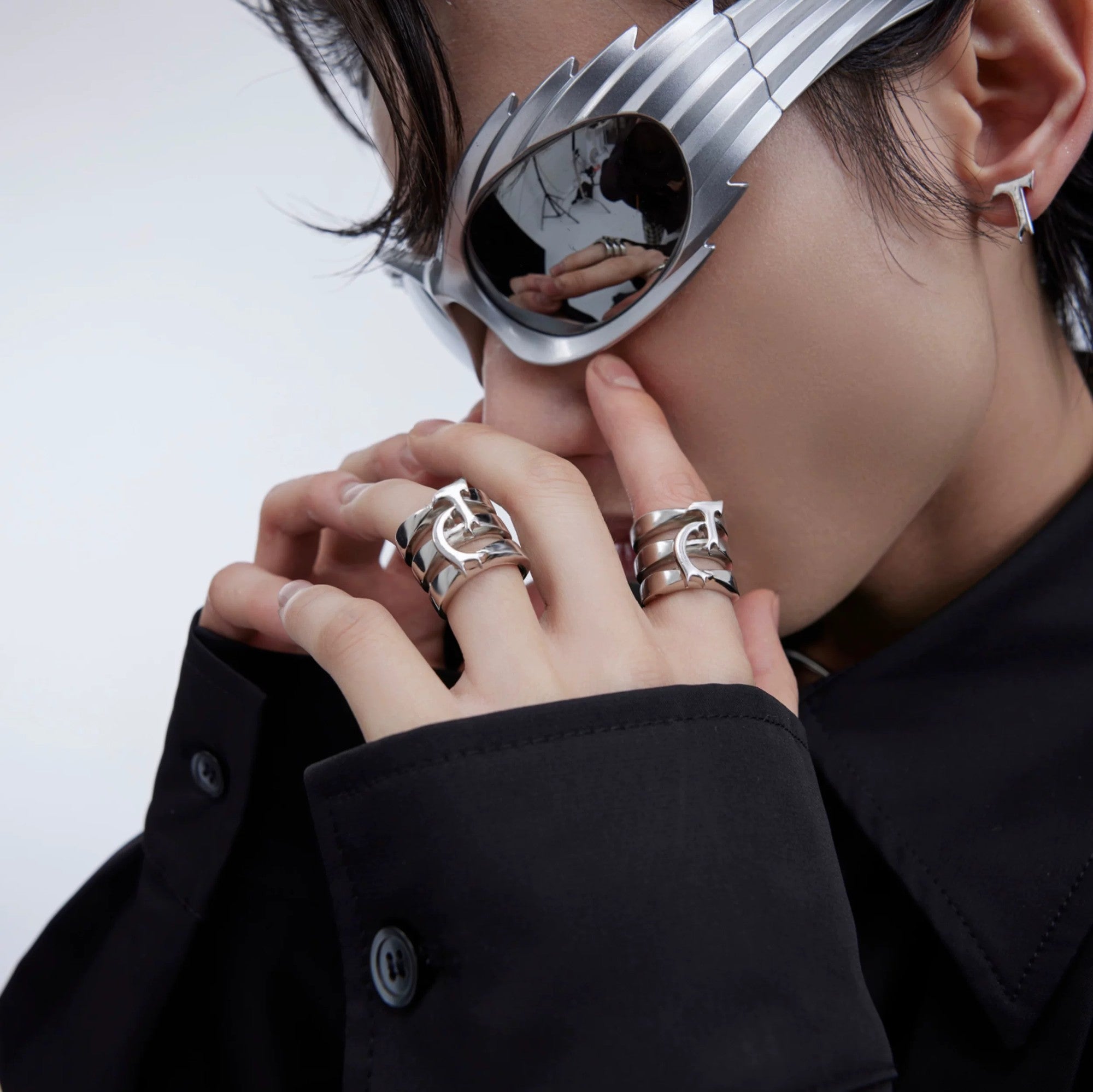 Close-up of a futuristic silver titanium steel claw ring on a hand.