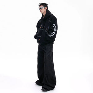 Detail shot of kangaroo pocket and ribbed cuffs on black hoodie.