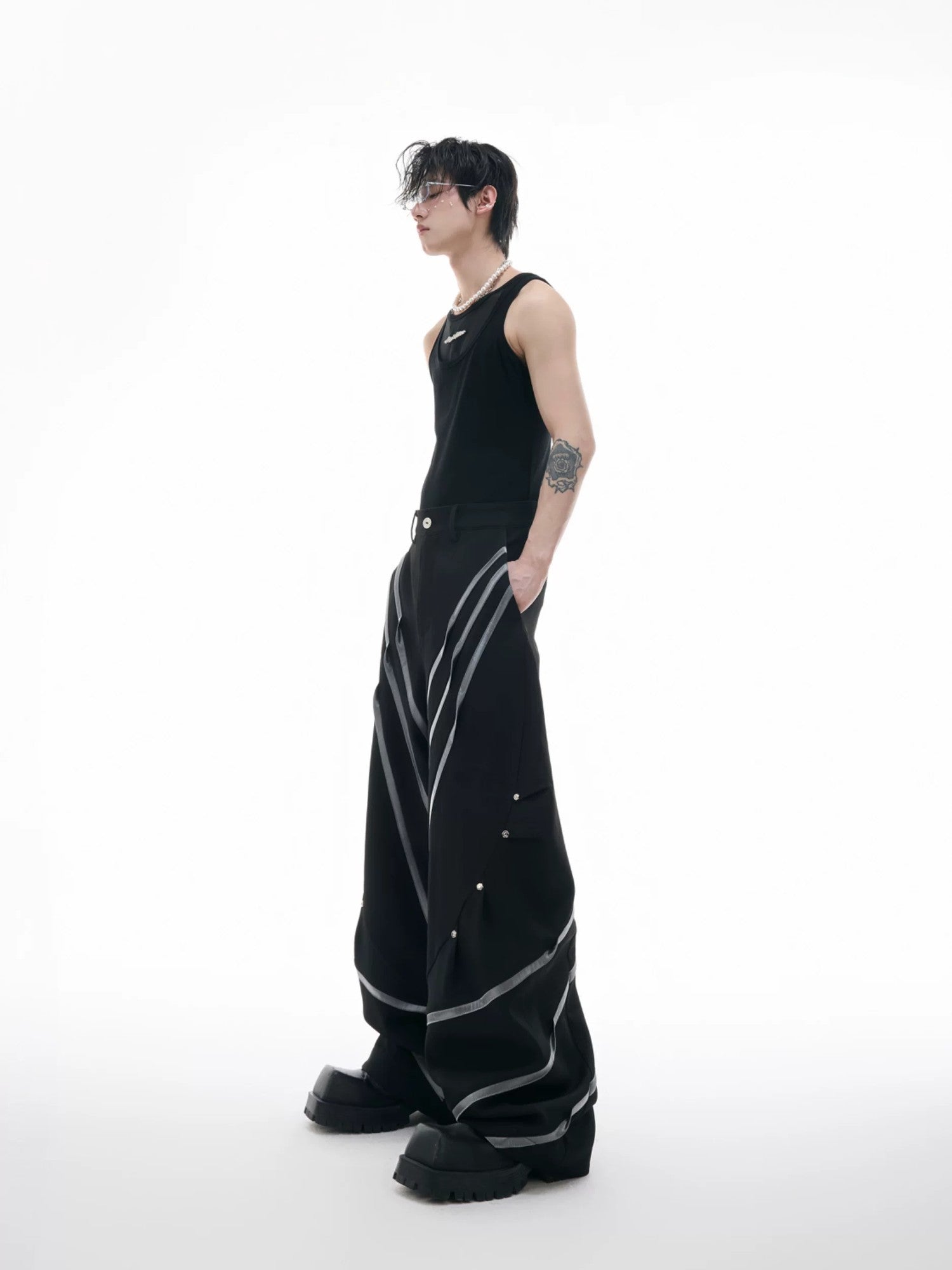 Model wearing black 3D cut trousers in an urban street setting