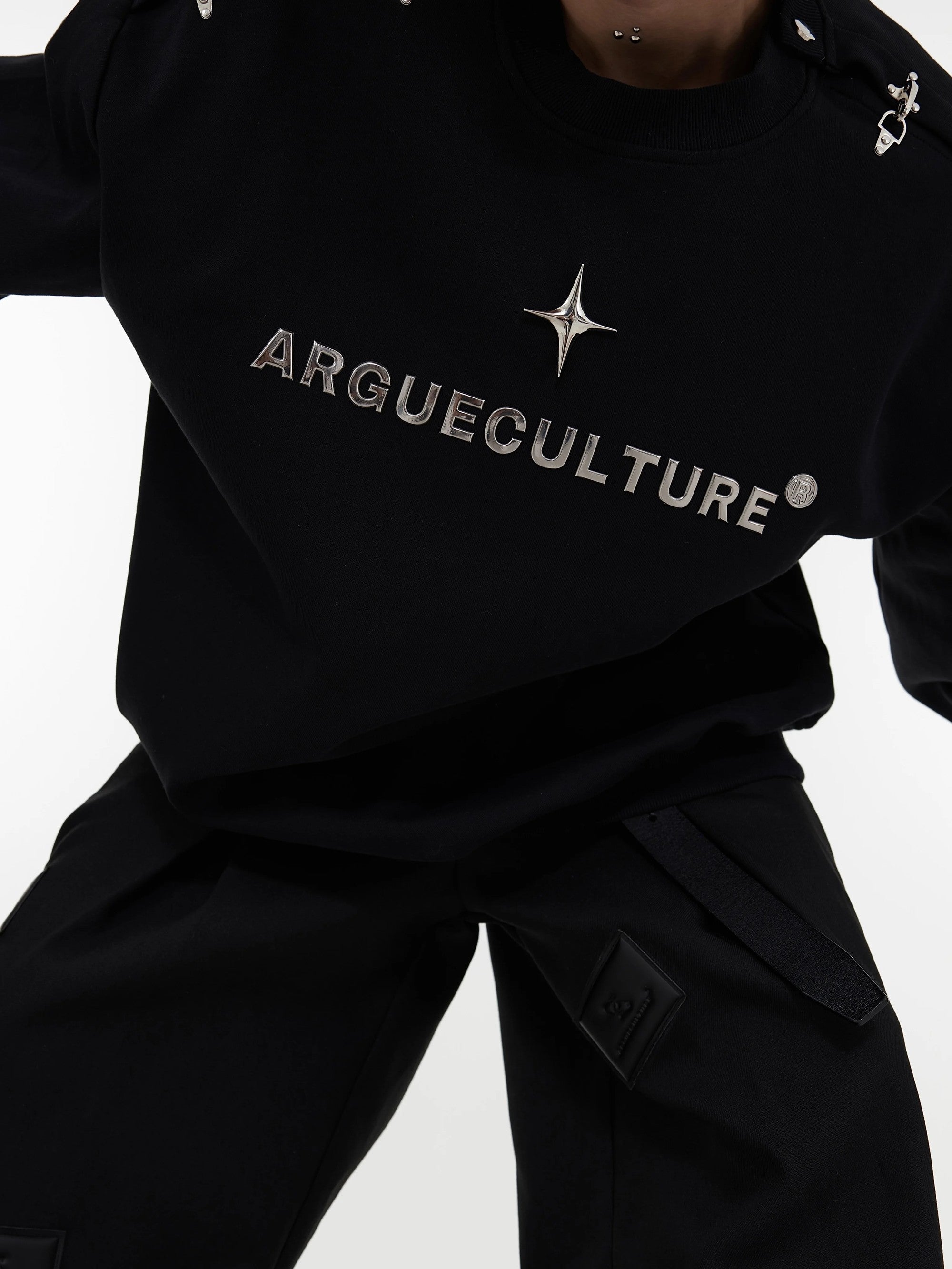 Close-up of the metal airplane buckle design on a designer sweatshirt