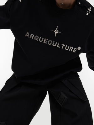 Close-up of the metal airplane buckle design on a designer sweatshirt