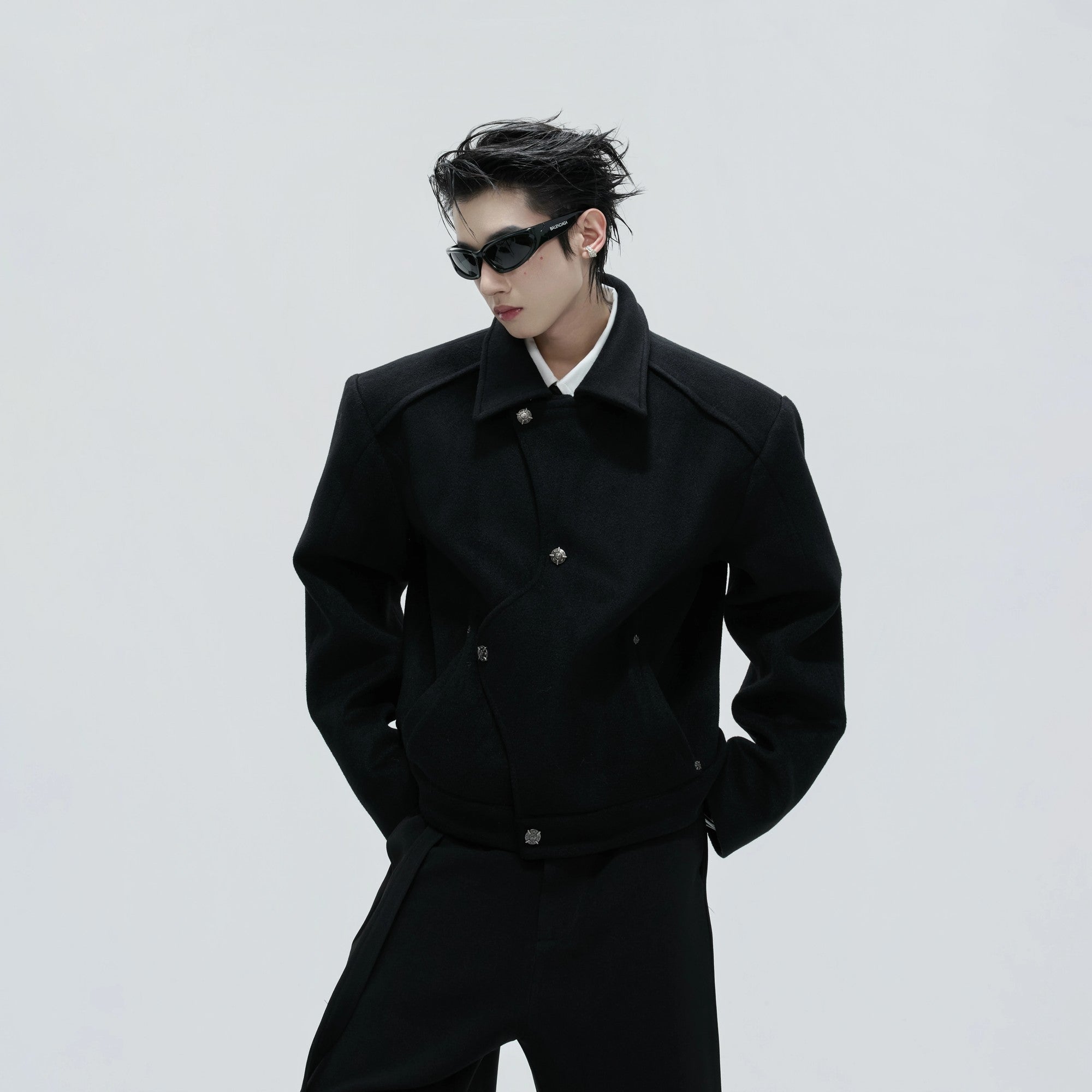 Side view of black deconstructed wool jacket showing asymmetric tailoring