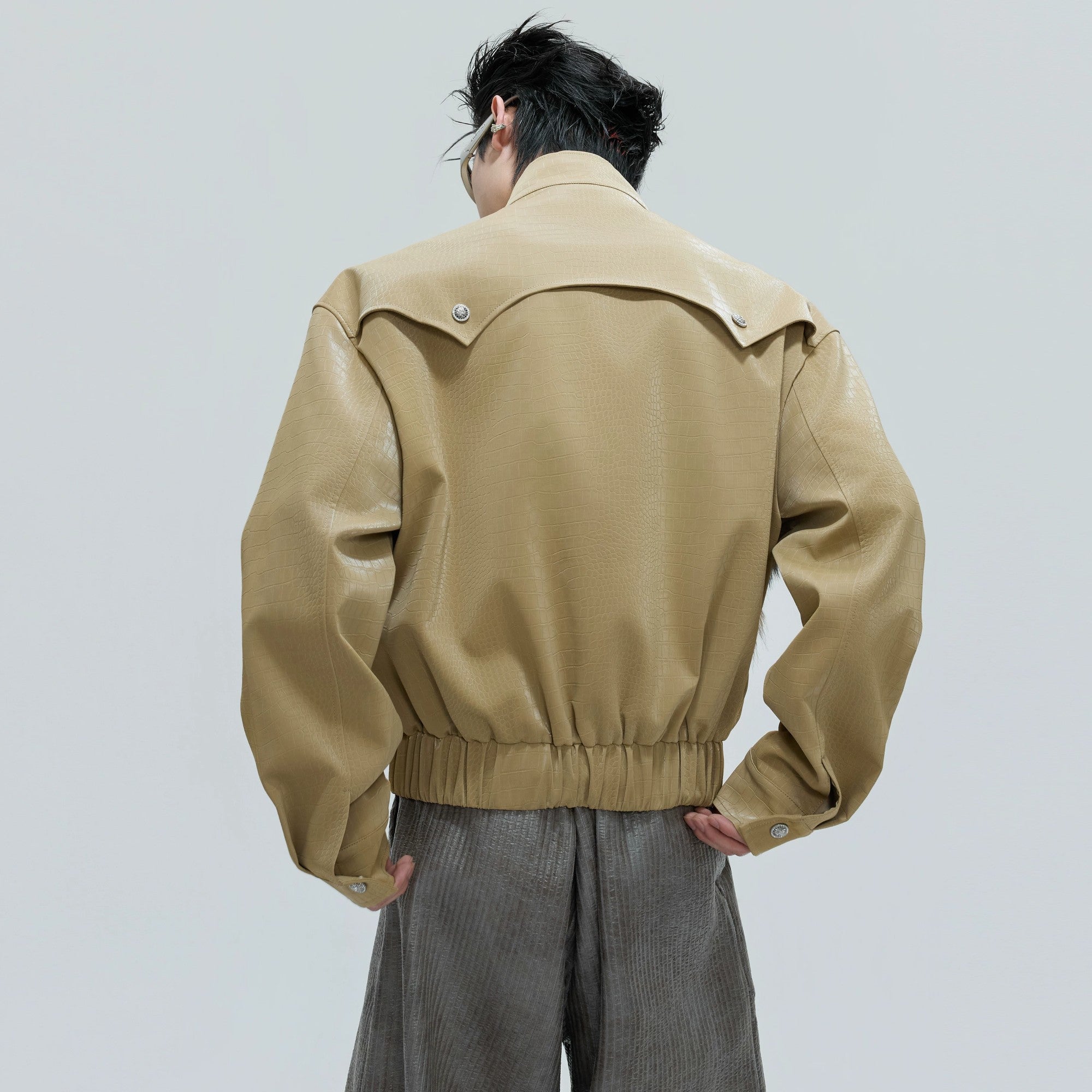 Detailed shot of carved metal buttons and faux crocodile leather texture