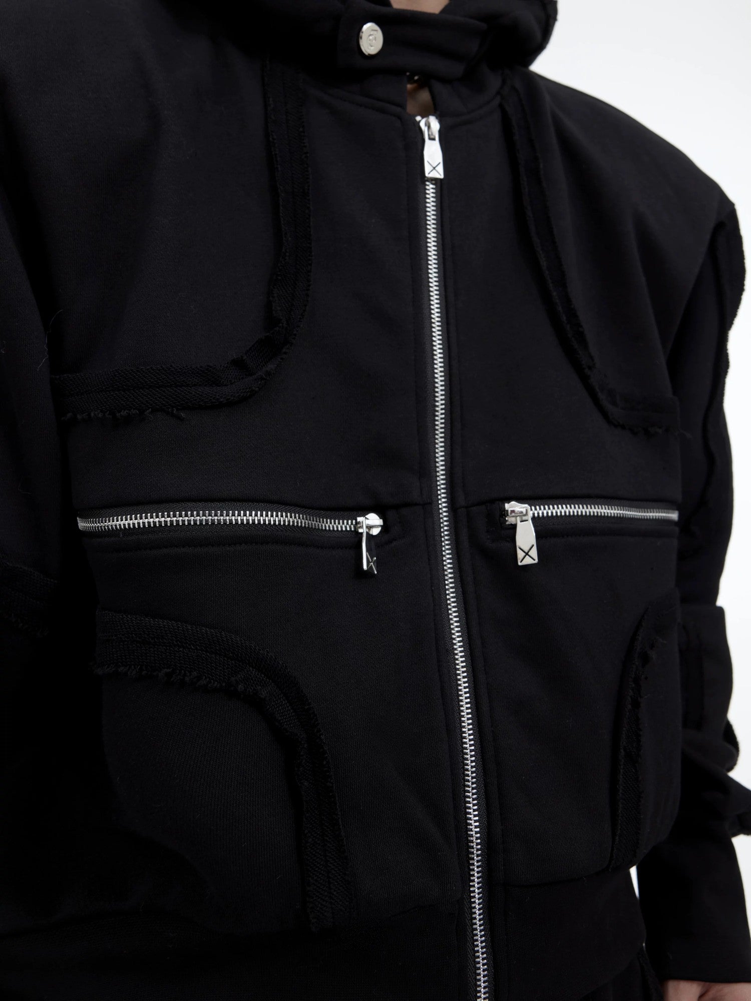 Back view of deconstructed hoodie showing 3D cutting and exposed seams