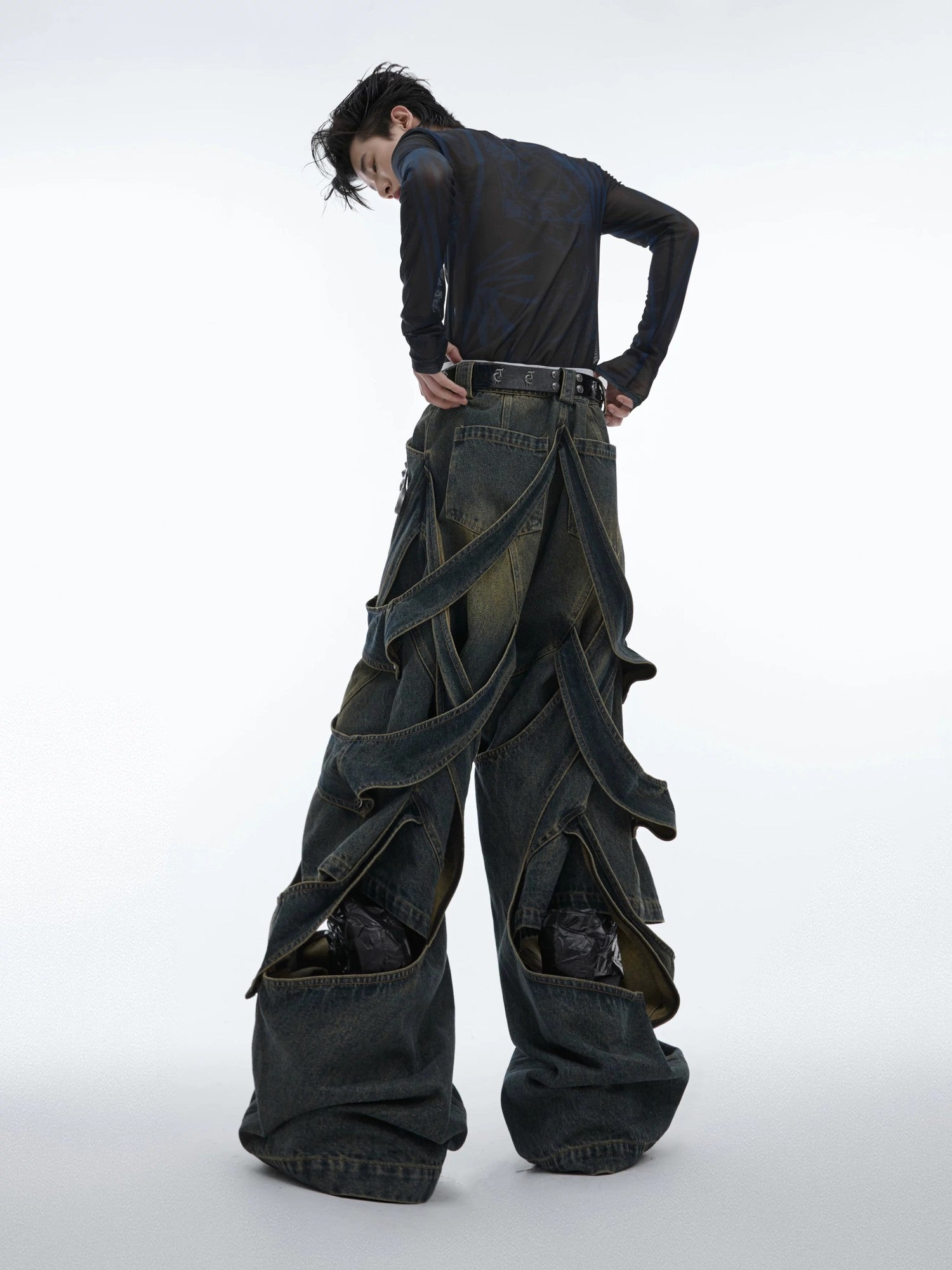 Model wearing blue deconstructed wide-leg denim pants in a street setting