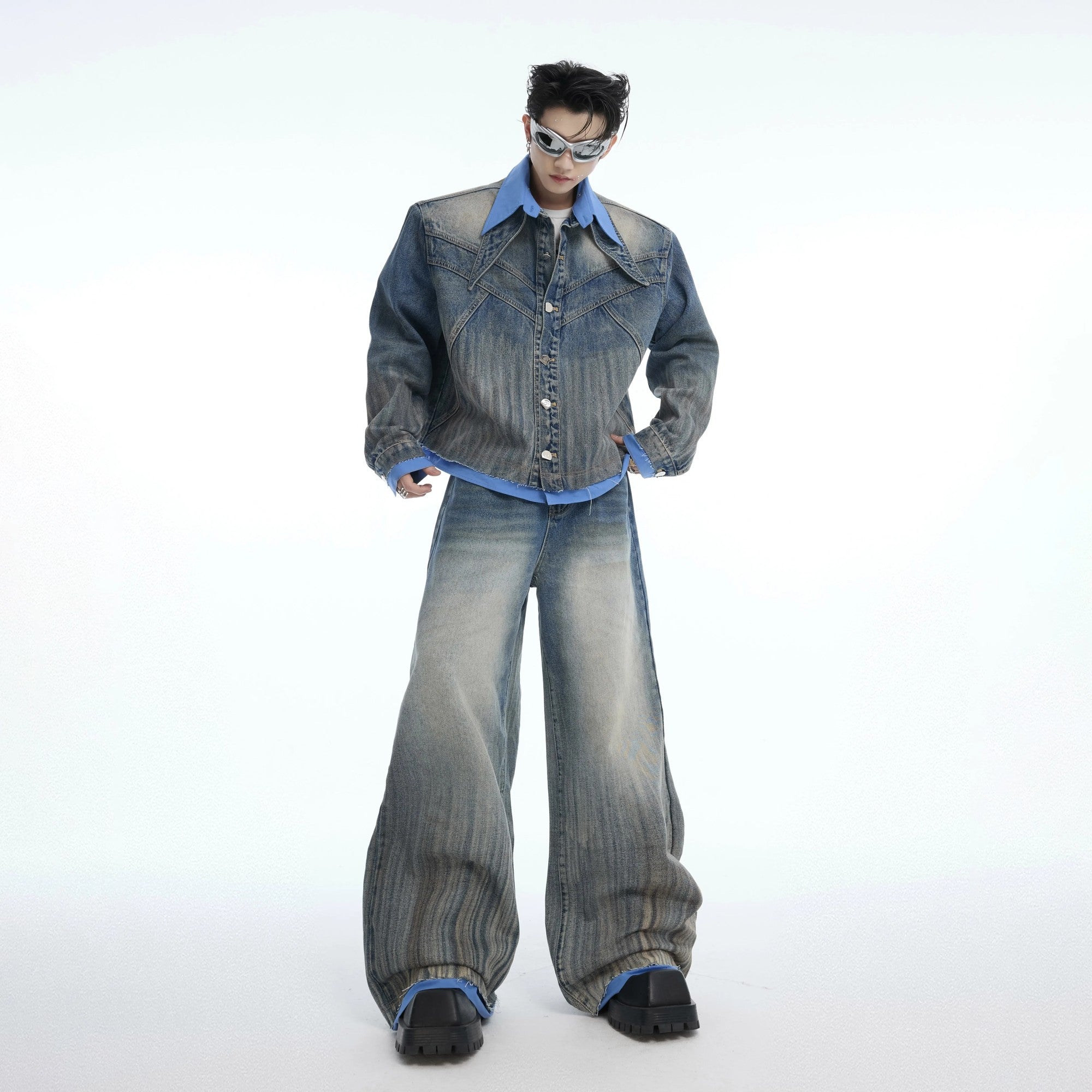 Close up of a blue deconstructed denim jacket with faux layered details.