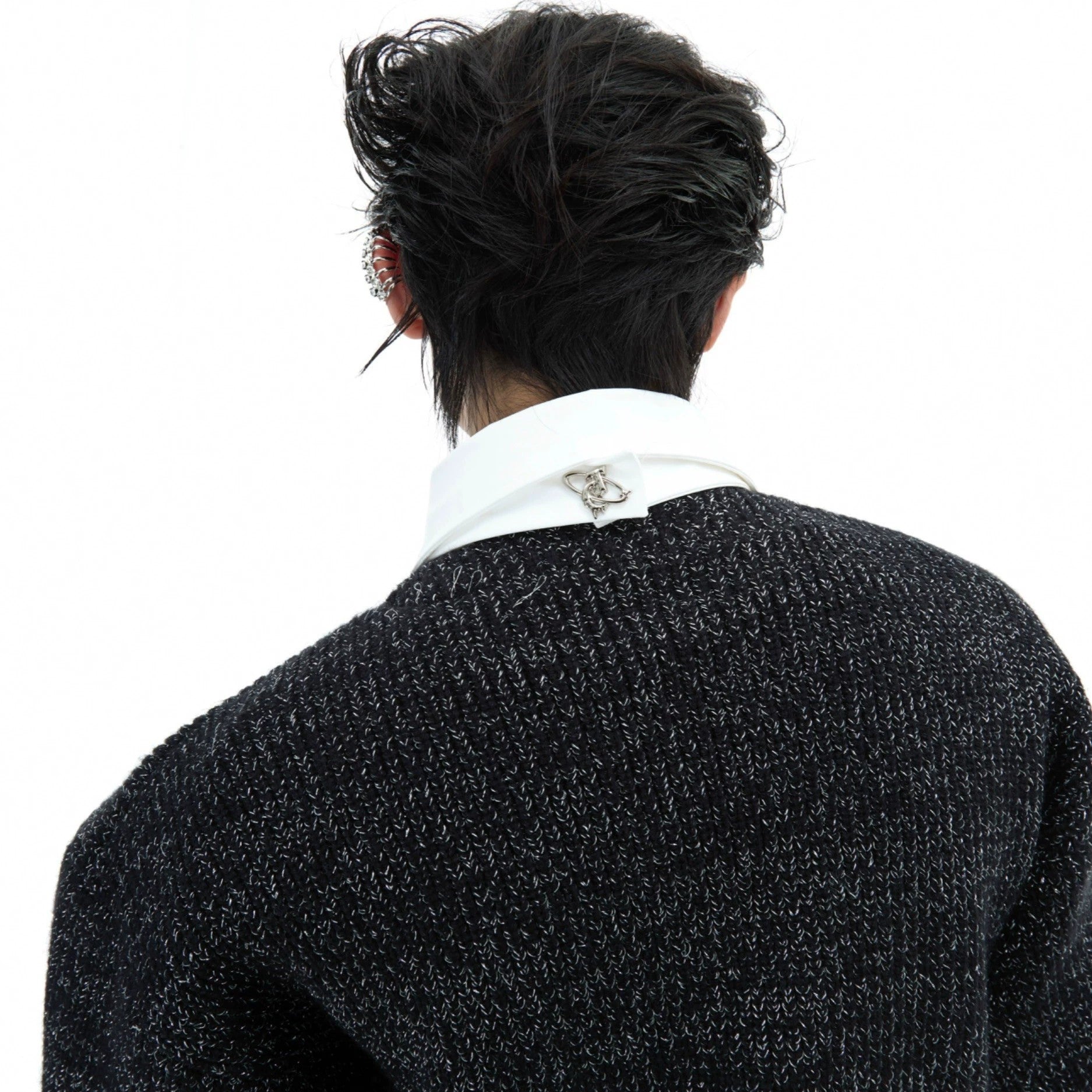 Close-up of the built-in tie and hardware detailing on the knit sweater.