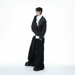 Model wearing a grey layered tie sweater in an urban street setting.