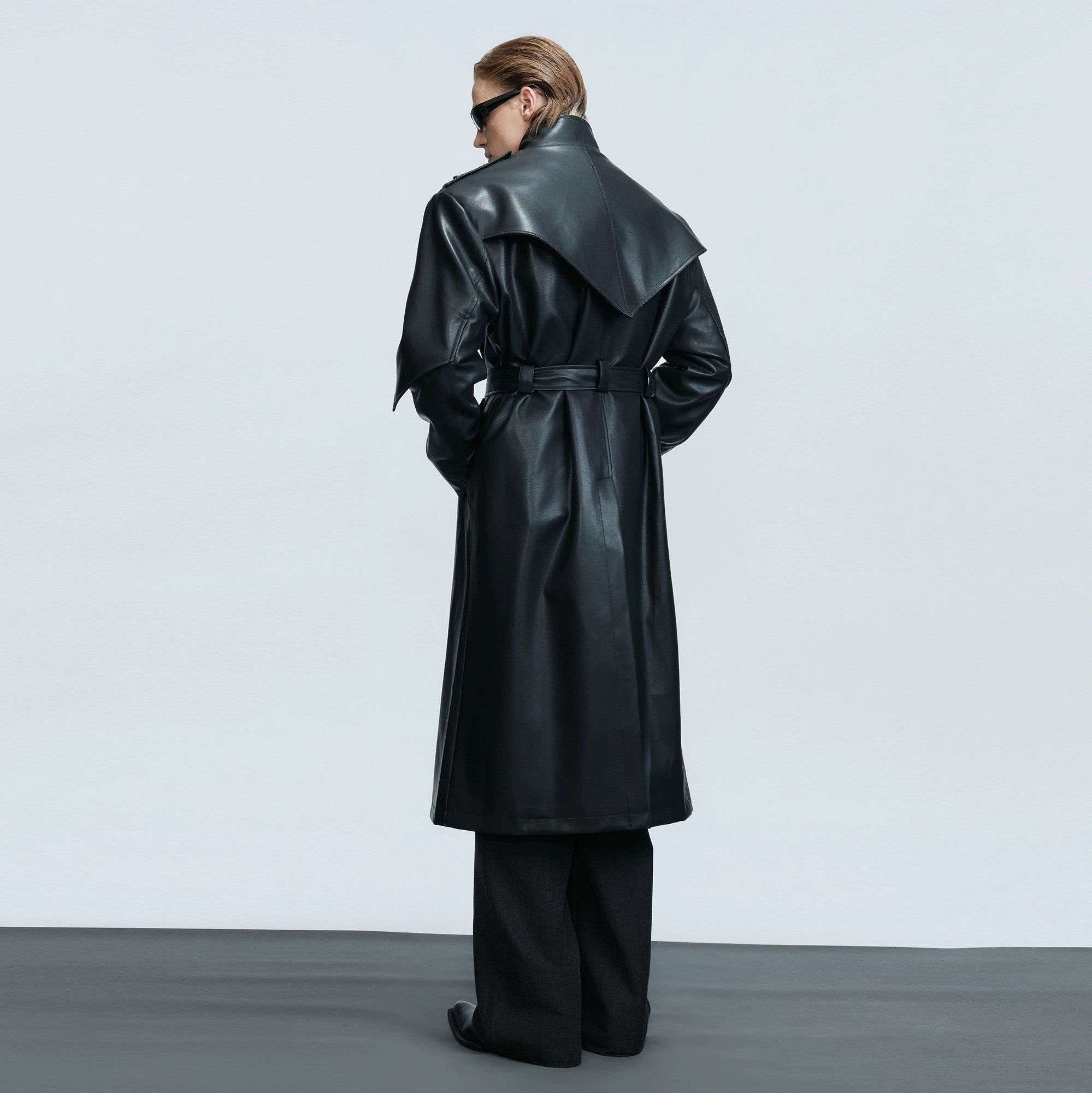 Model wearing a cinched waist deconstructed leather trench coat