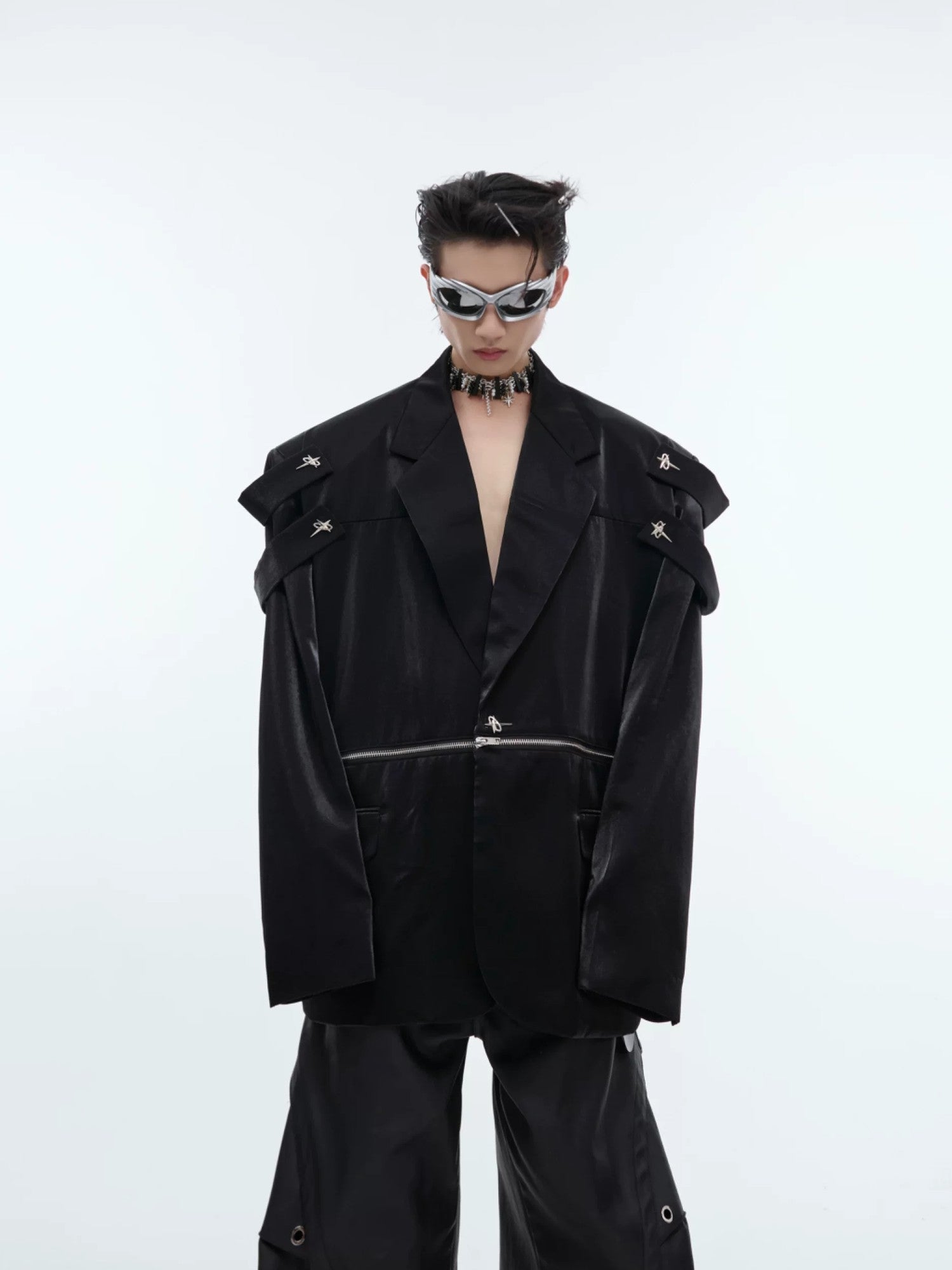 Close-up of split shoulder design and metallic accents on a black blazer