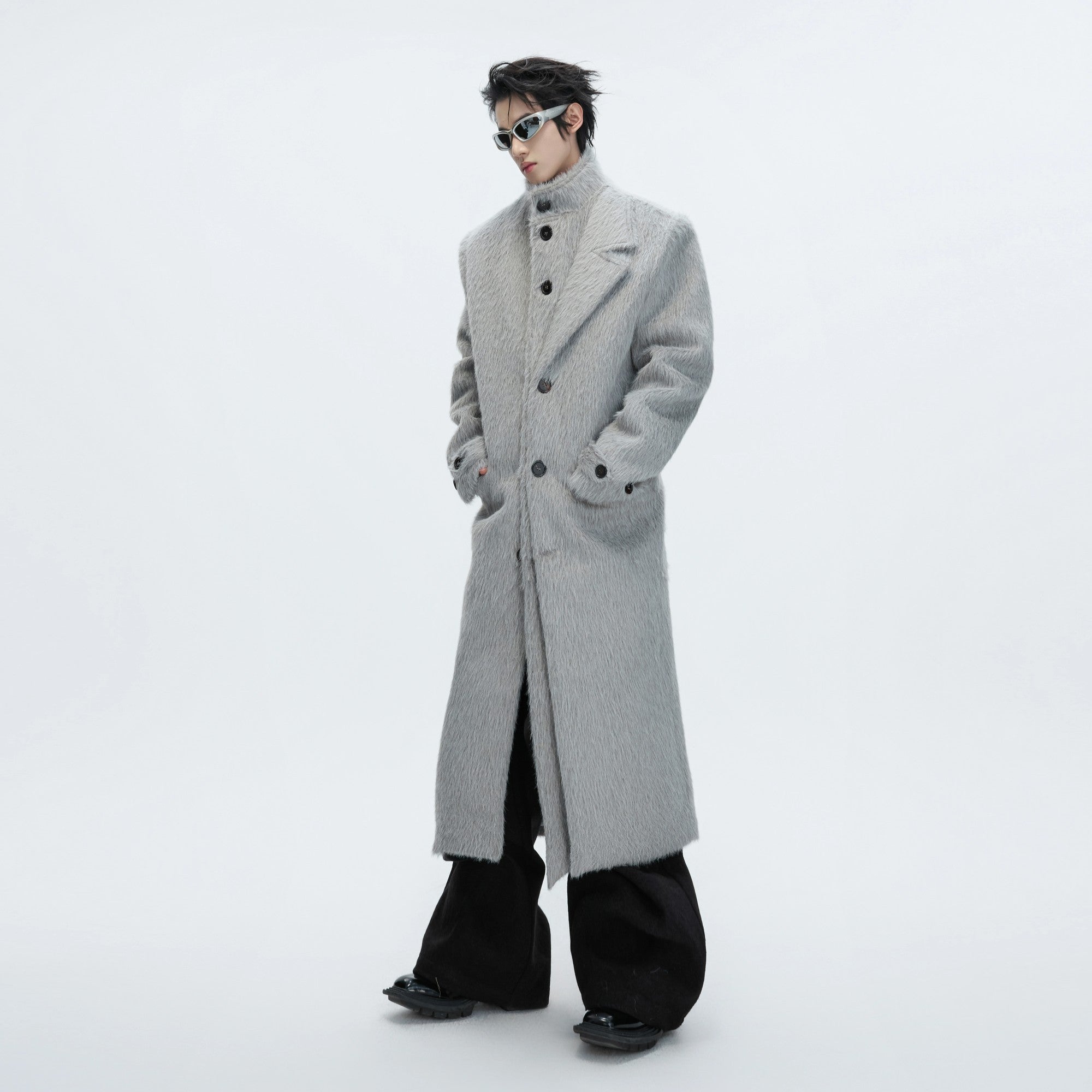 Front view of a long deconstructed wool trench coat in street style