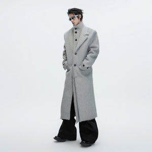 Front view of a long deconstructed wool trench coat in street style