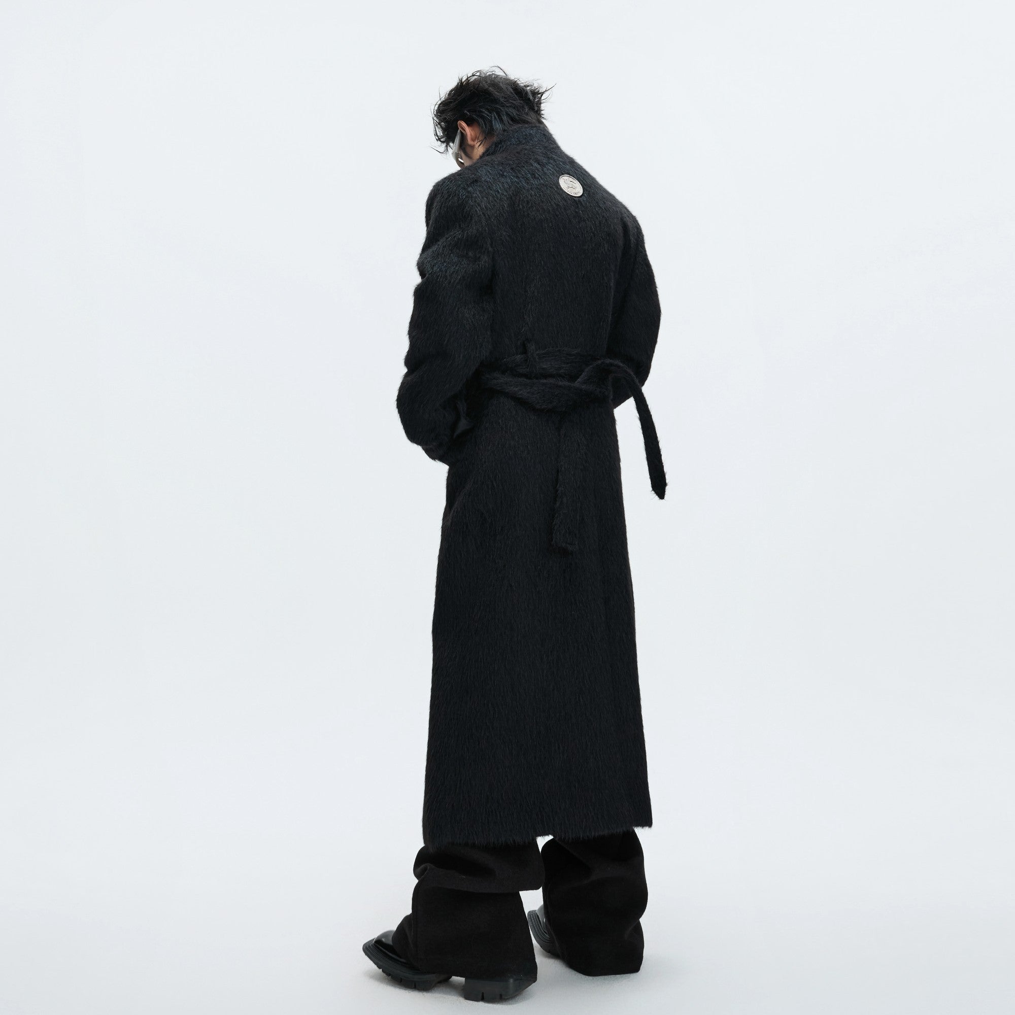 Model wearing a long white wool trench coat in an urban setting