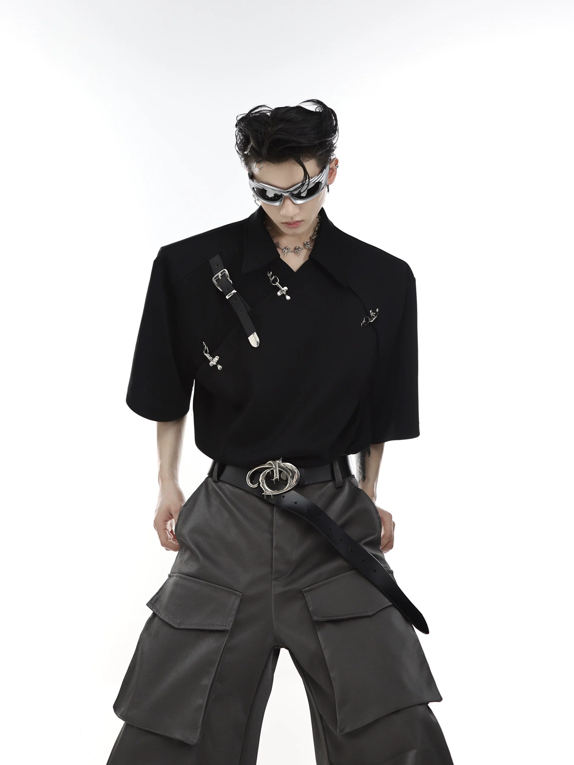 Close-up of asymmetric metal buckle neckline and shoulder pad detail