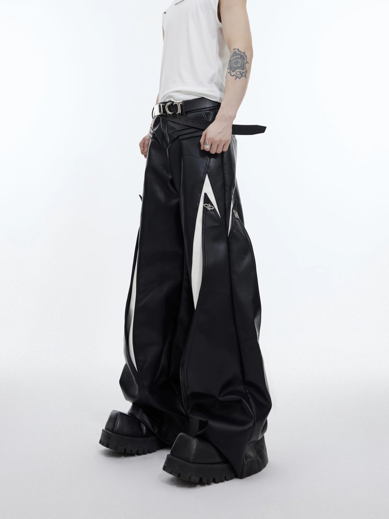 Men's black deconstructed PU leather pants with metal button details