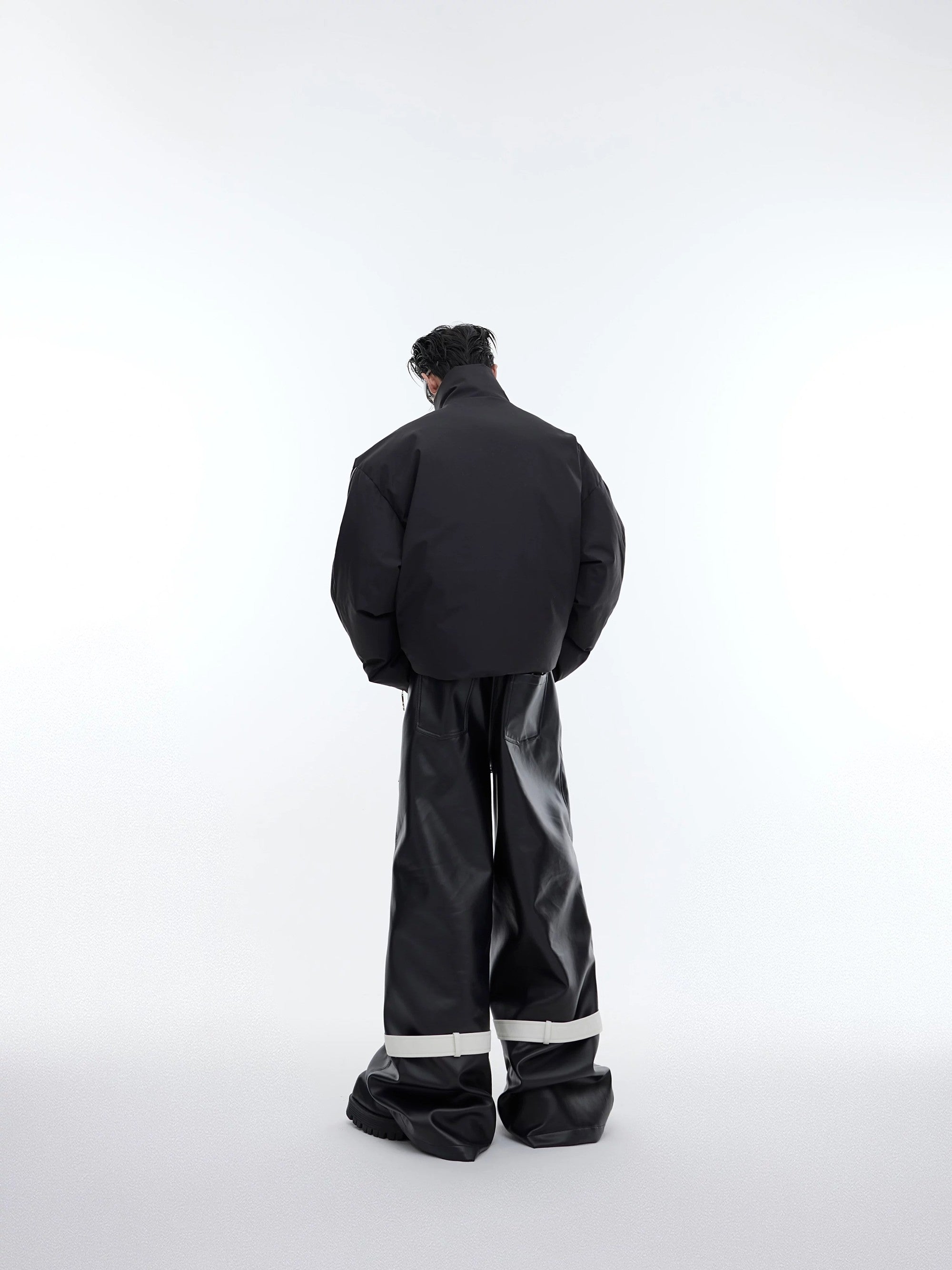 Male model wearing deconstructed zip puffer jacket with baggy pants
