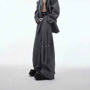 Model wearing a full black deconstructed suit set with wide-leg pants.