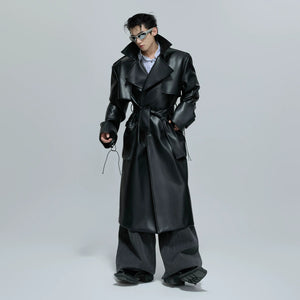 Front view of a black deconstructed leather trench coat with padded shoulders