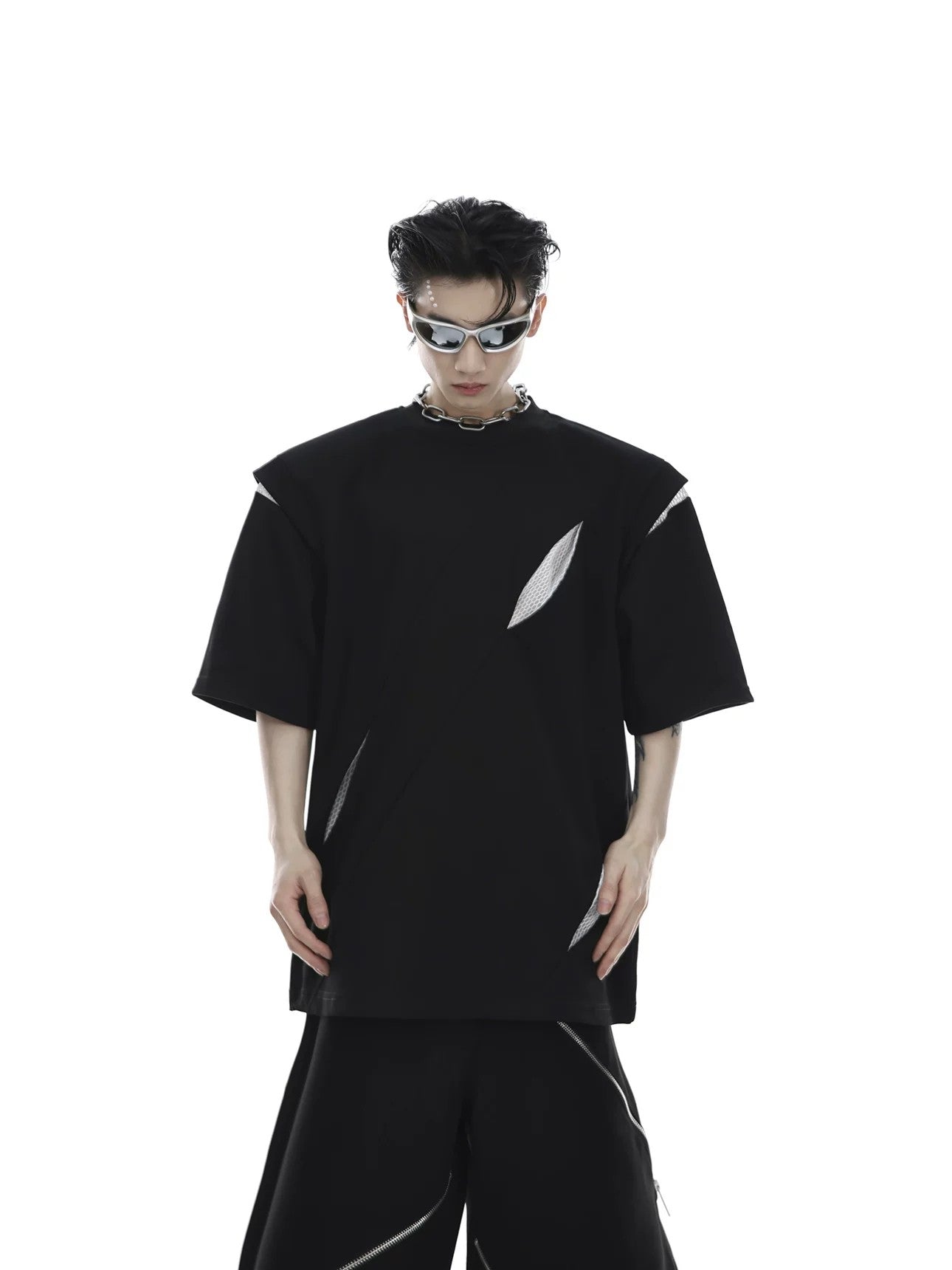 Unisex model wearing black oversized deconstructed T-shirt in urban setting