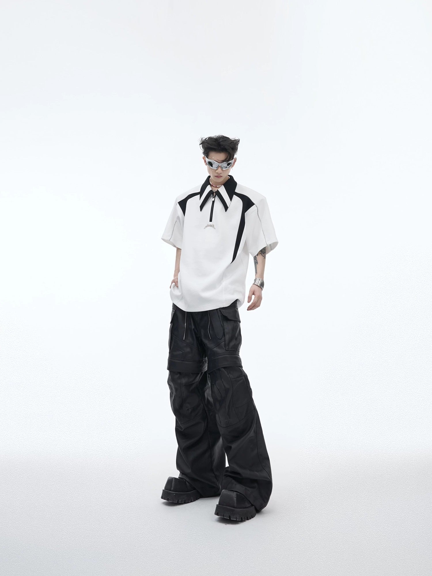 Male model wearing a deconstructed polo with baggy trousers in a city setting.