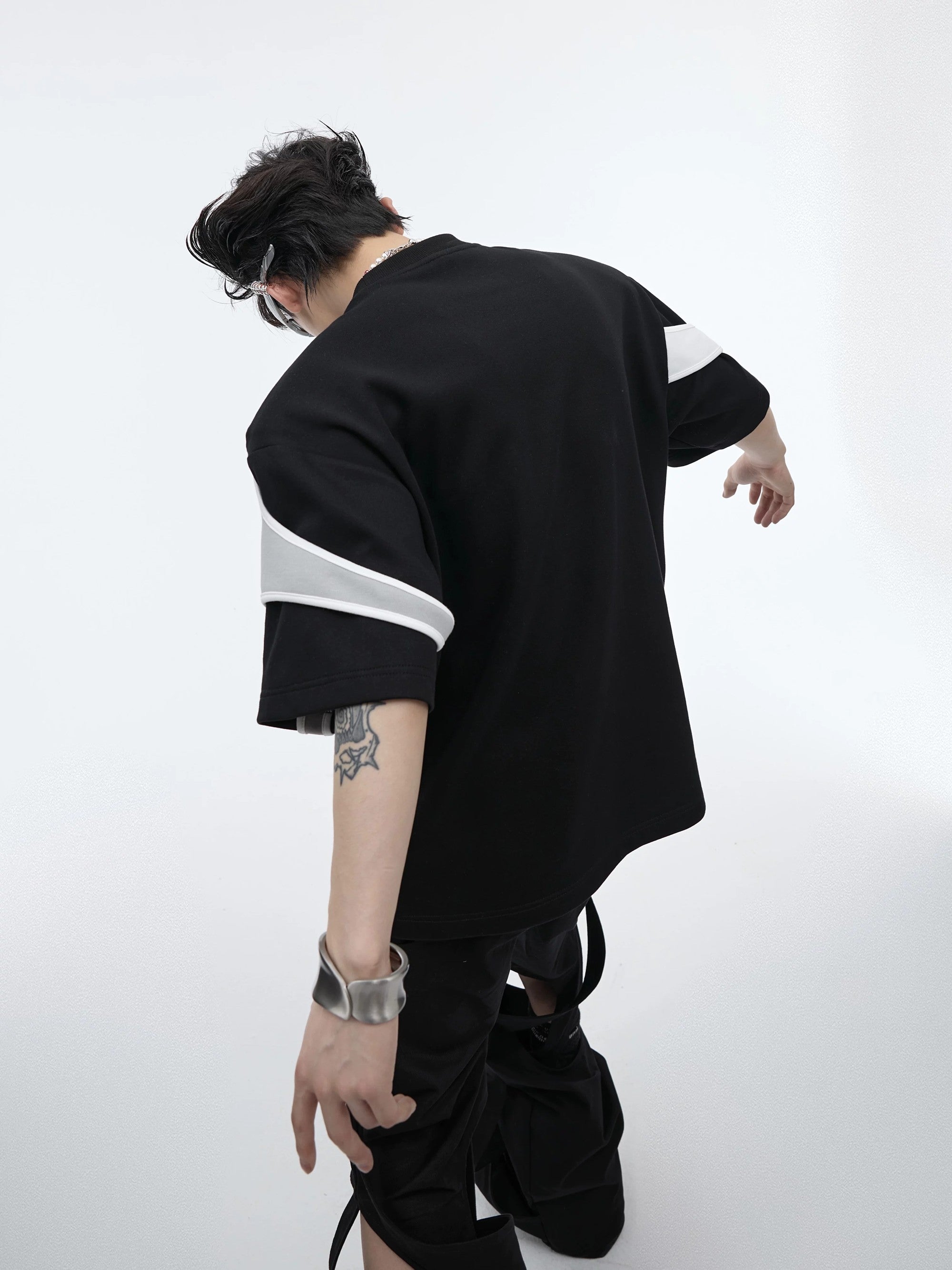 Male model wearing a red boxy deconstructed tee in an urban setting