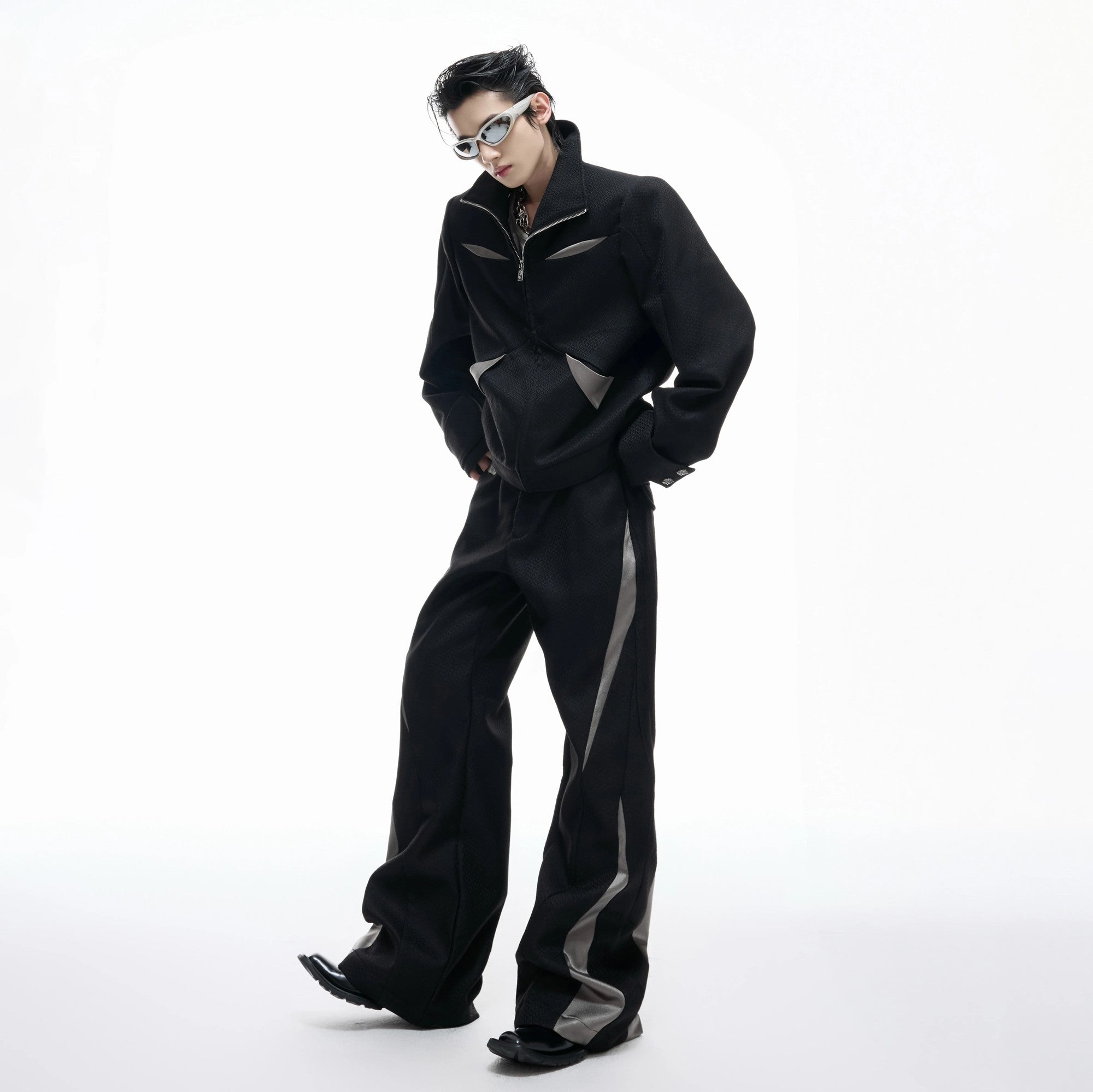 Front view of black deconstructed patchwork cropped jacket and flare pants set