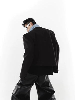 Close up of padded shoulders and patchwork fabric on a streetwear jacket.