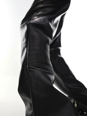 Close-up of the side slit and micro-flare hem on black leather pants