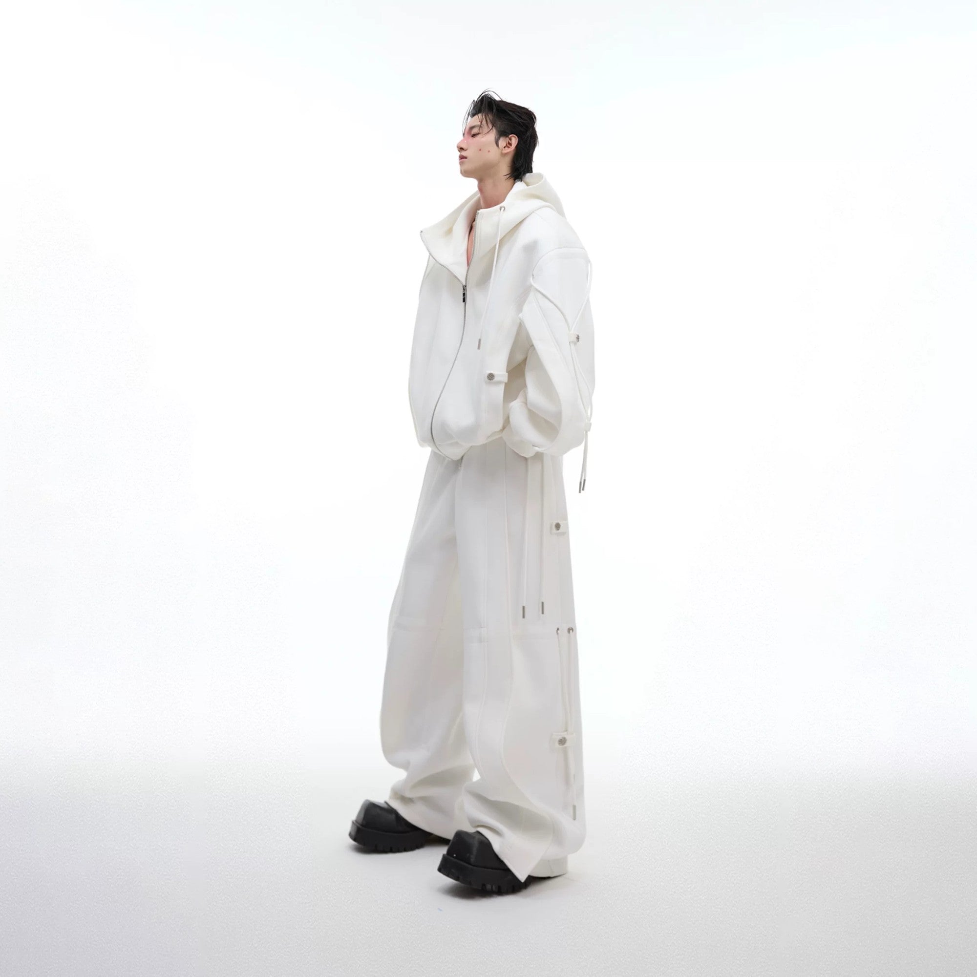 Model wearing white deconstructed wide-leg trousers in a street setting