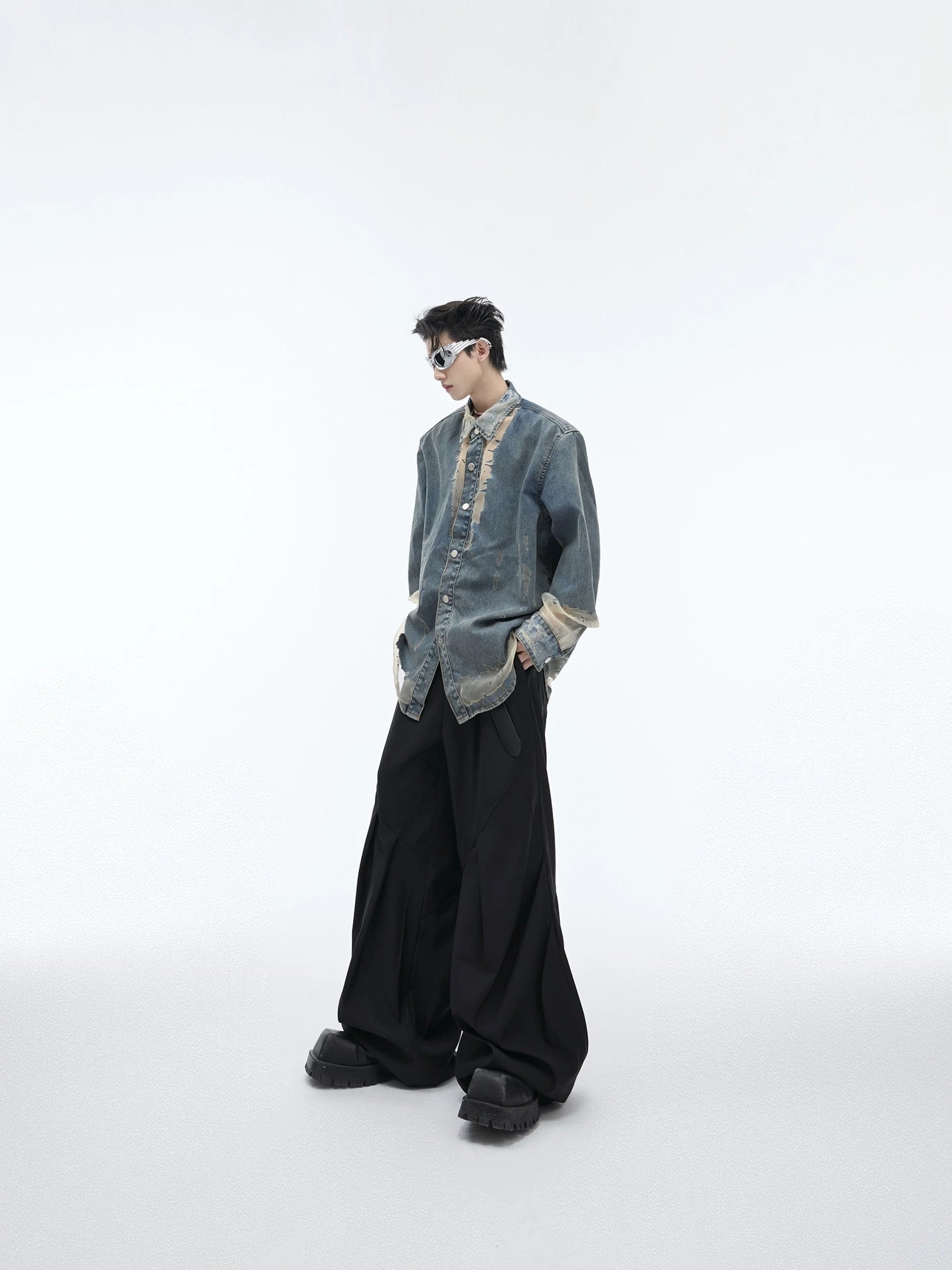 Lifestyle shot of the avant-garde deconstructed denim shirt in light blue.