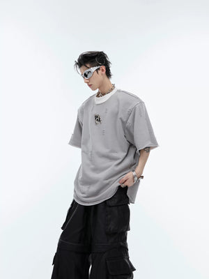 Back view of loose fit deconstructed tee showing metal details and distressing