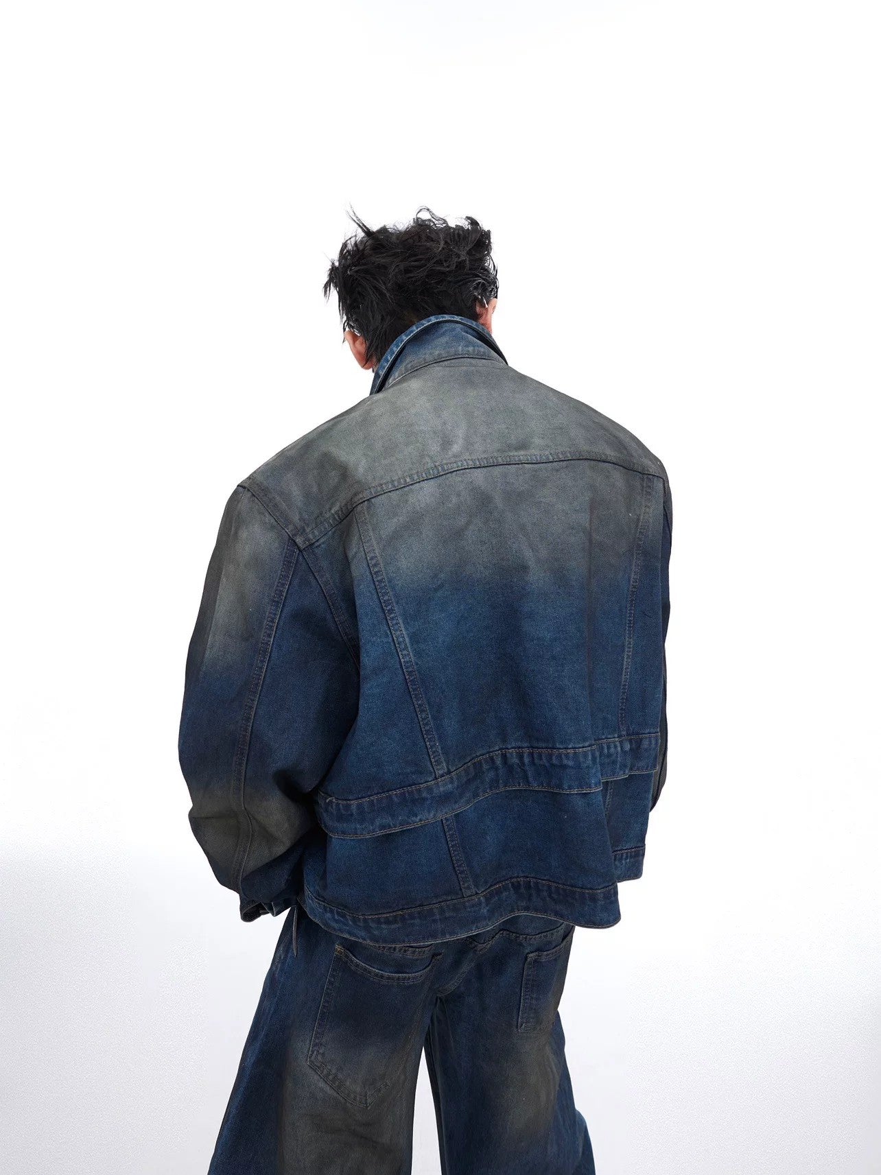 Side profile of loose fit distressed denim pants showing the gradient wash.