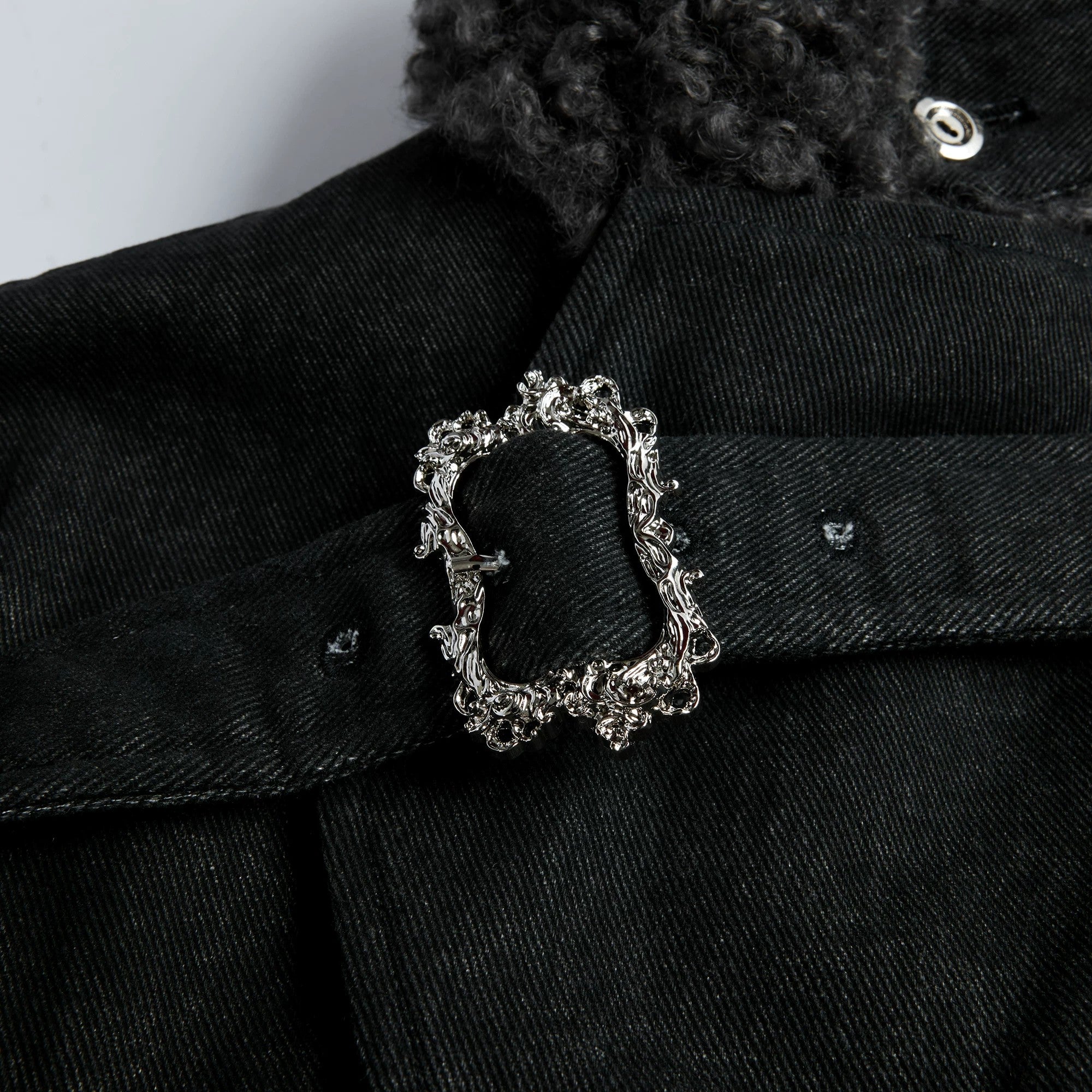 Model wearing oversized fur collar parka in urban setting