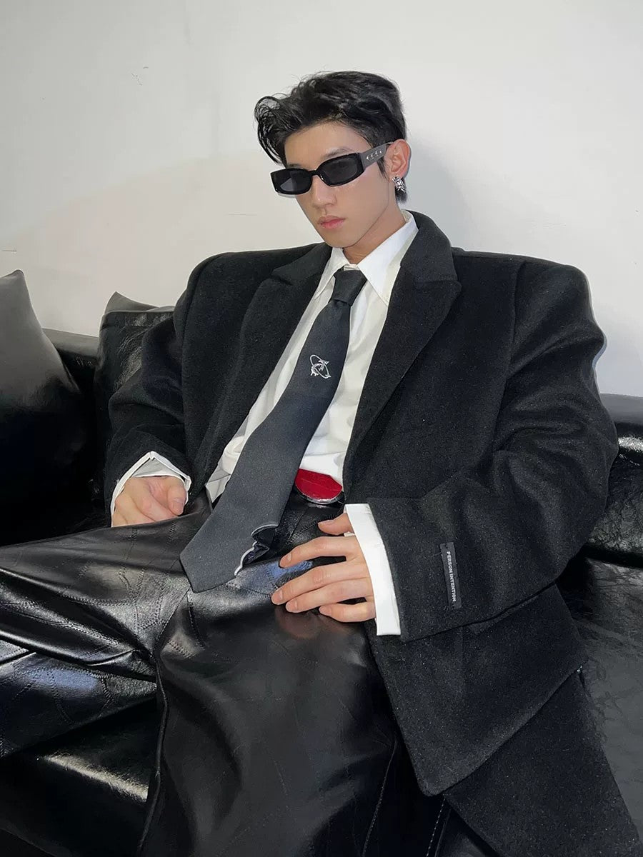 Model wearing a black distressed tie with an oversized streetwear blazer