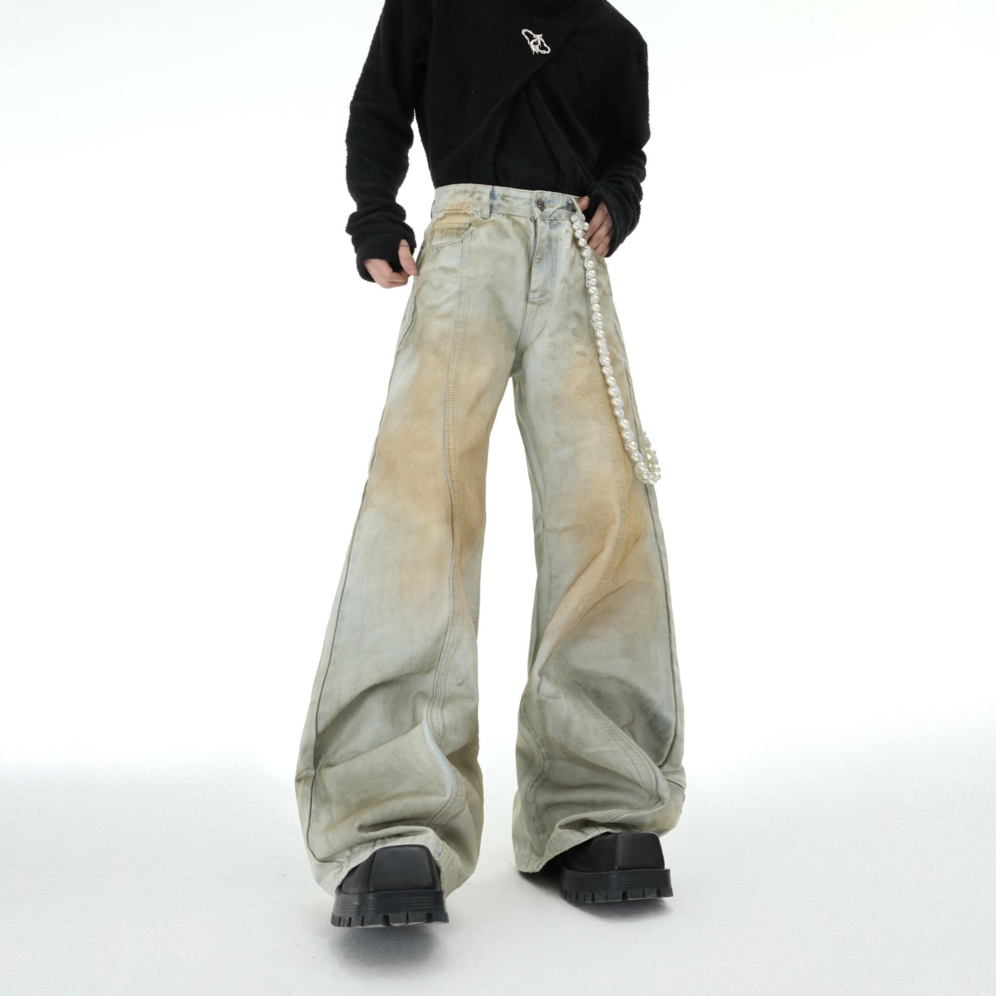 Front view of distressed flared jeans with detachable pearl charm