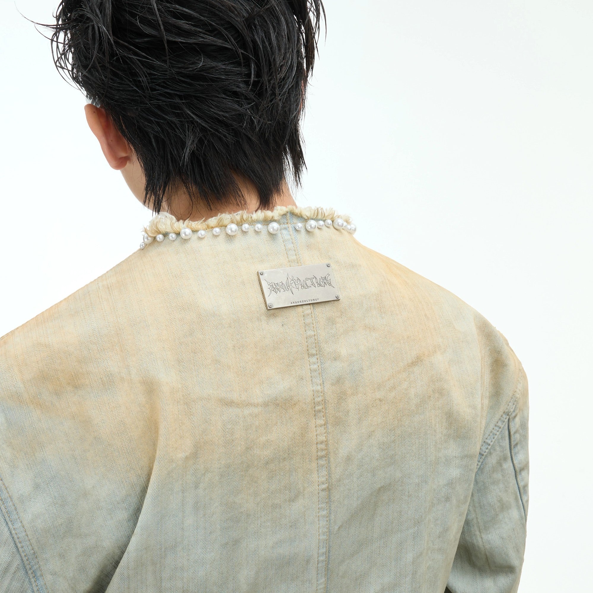 Close-up of hand-sewn pearl embellishments on blue denim fabric