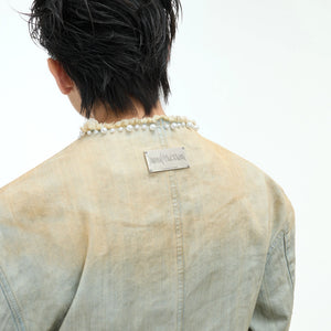 Close-up of hand-sewn pearl embellishments on blue denim fabric