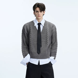 Model wearing a black cable knit polo sweater in a city street setting