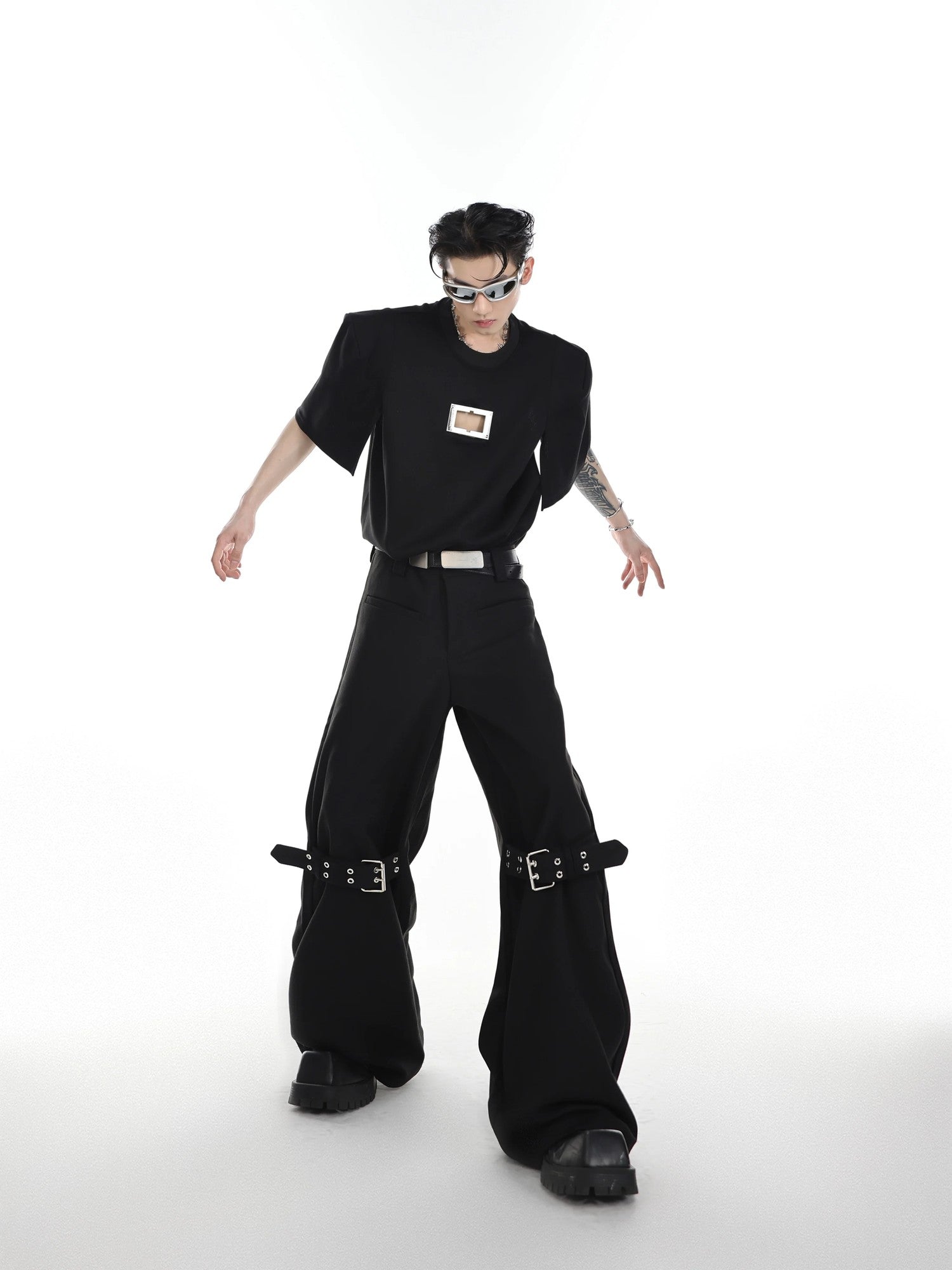 Back view showing the silhouette and fit of the strapped flare trousers.