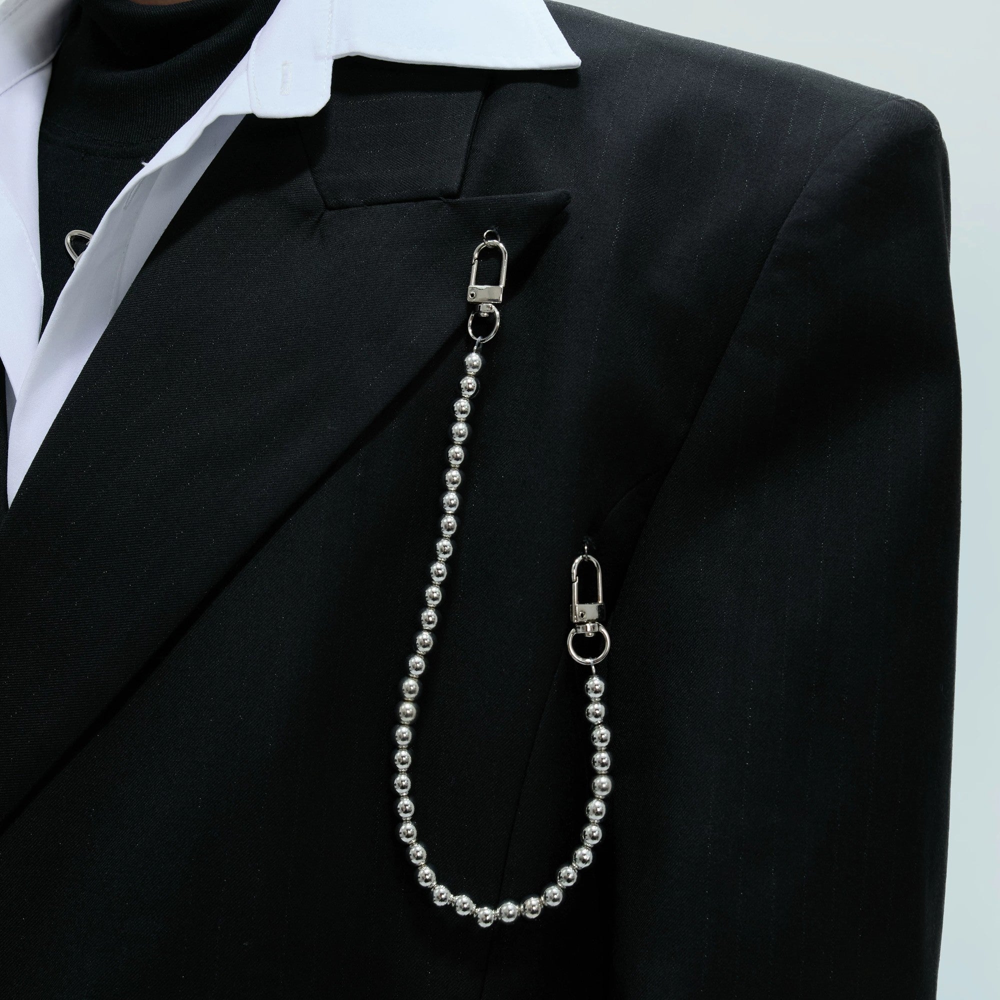 Silver metal chain detail on a black double breasted blazer