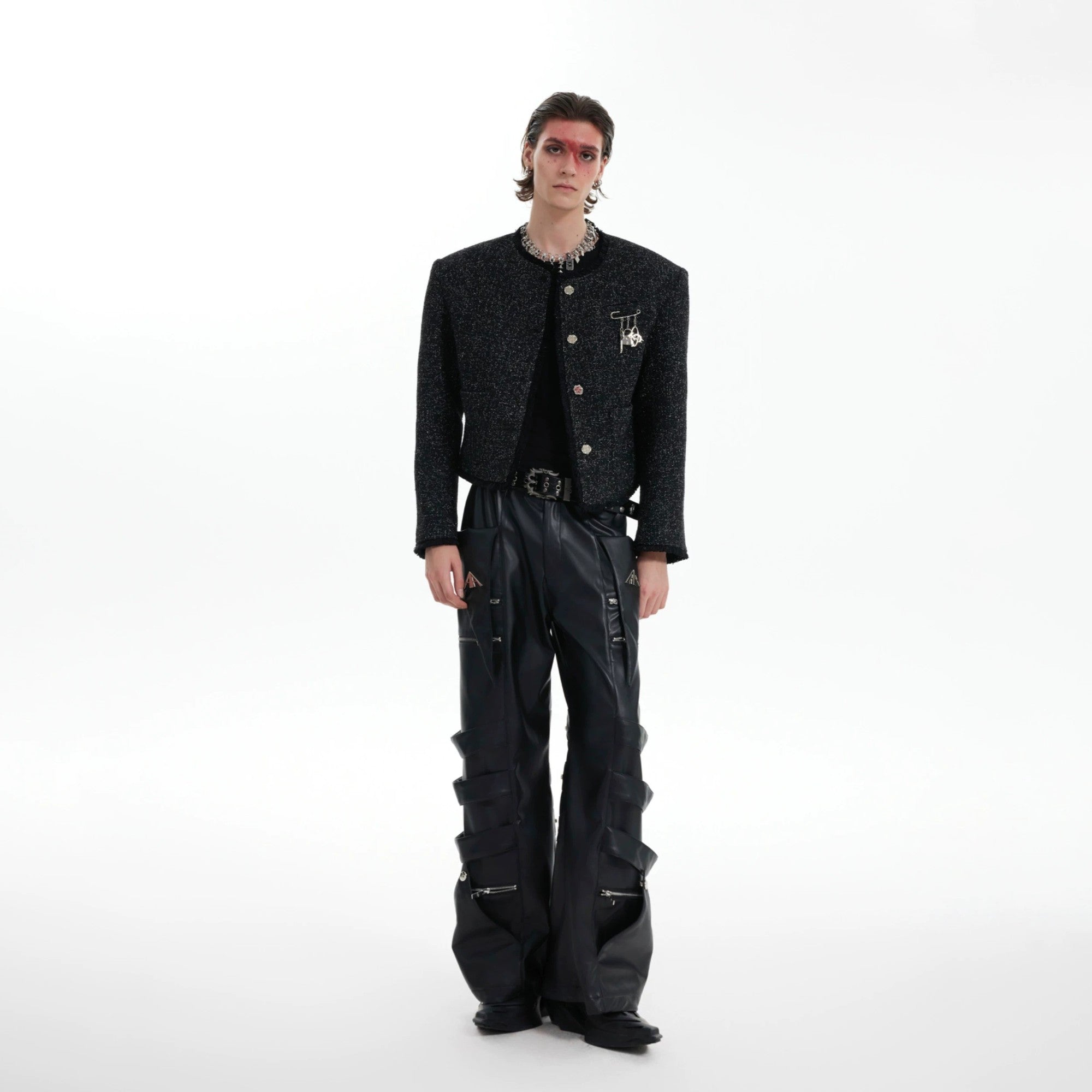 Close-up of the glossy texture and fringe detail on the cropped jacket