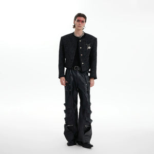 Close-up of the glossy texture and fringe detail on the cropped jacket